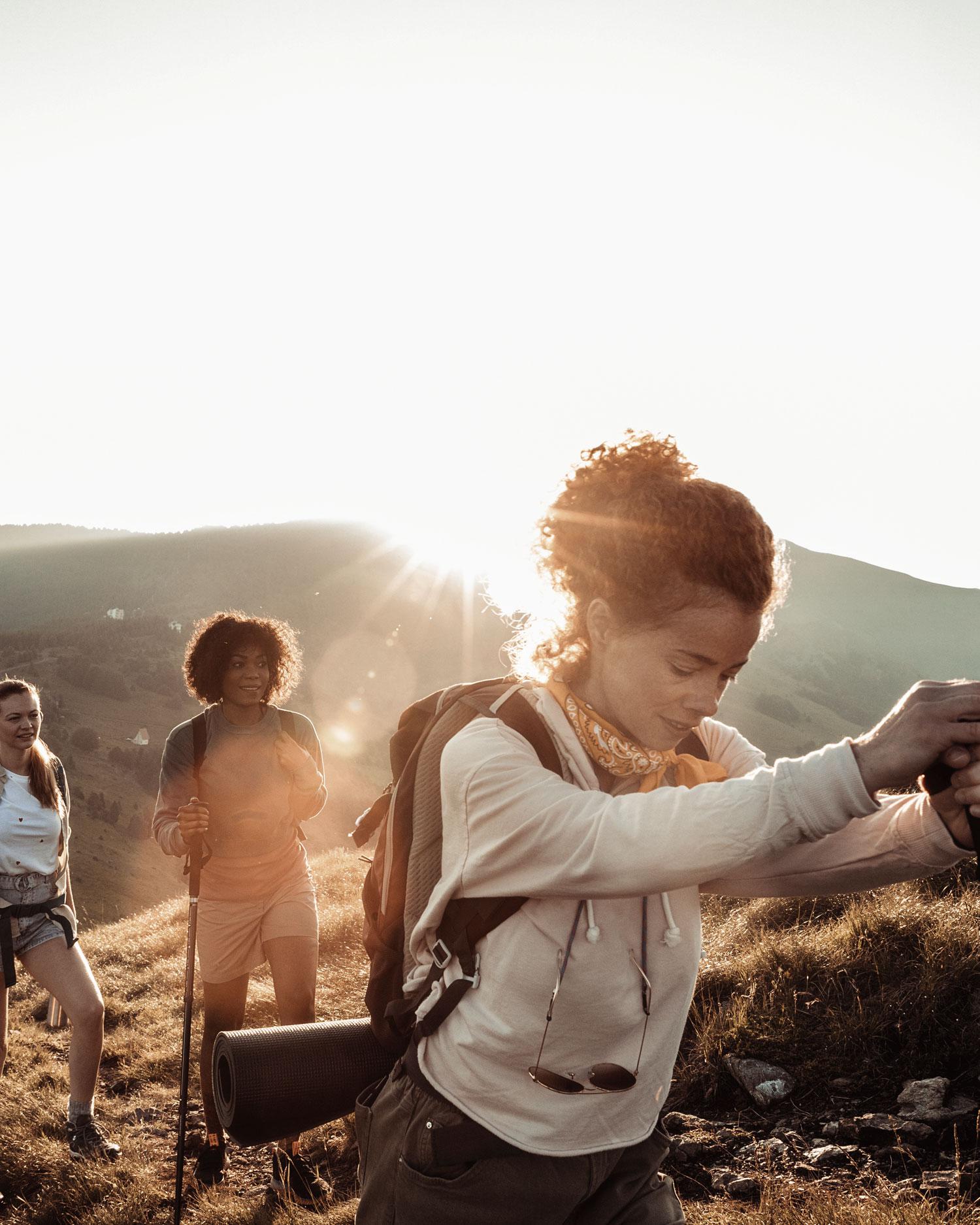three women hiking at sunset