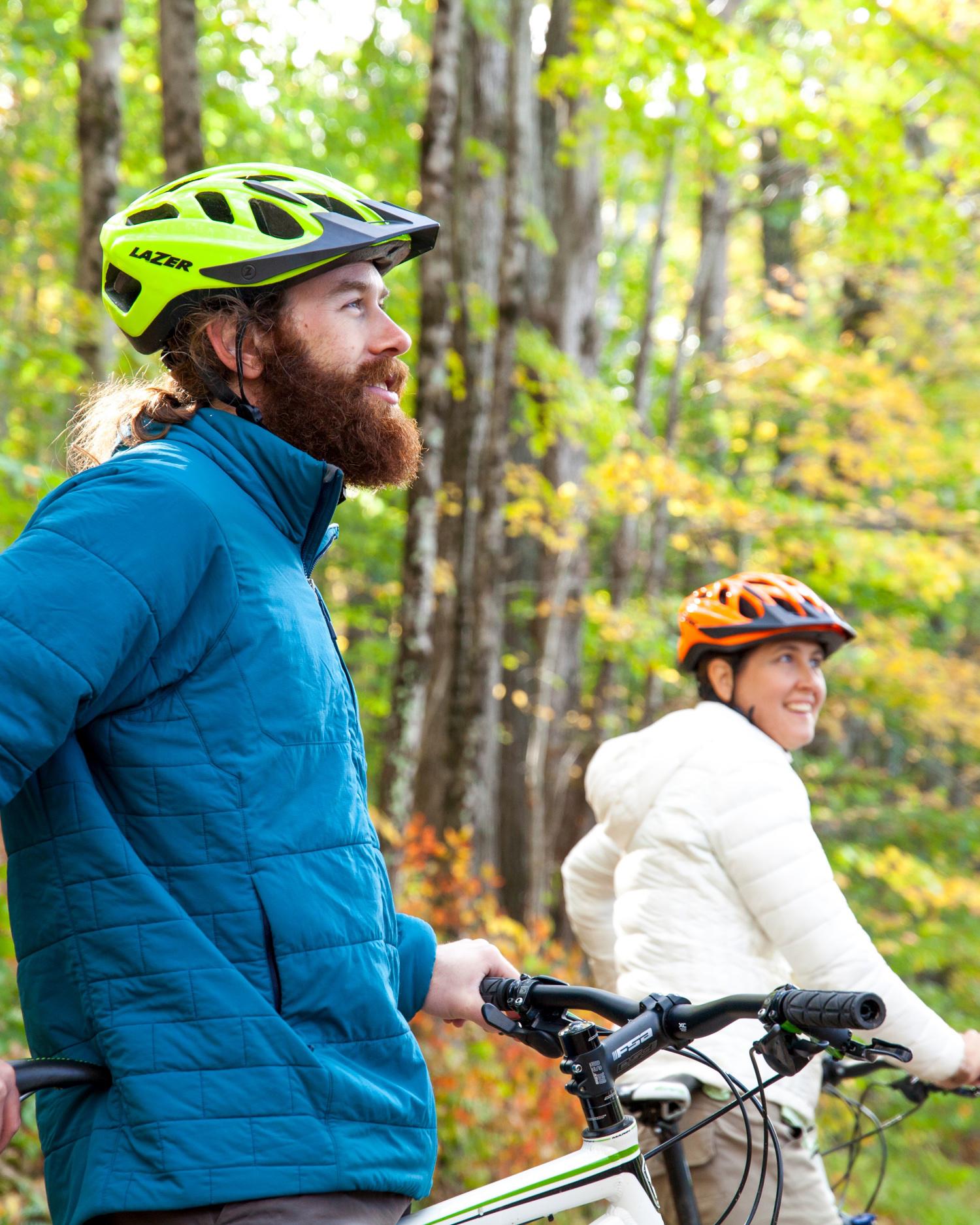 Man and woman on bicycles looking up and smiling.