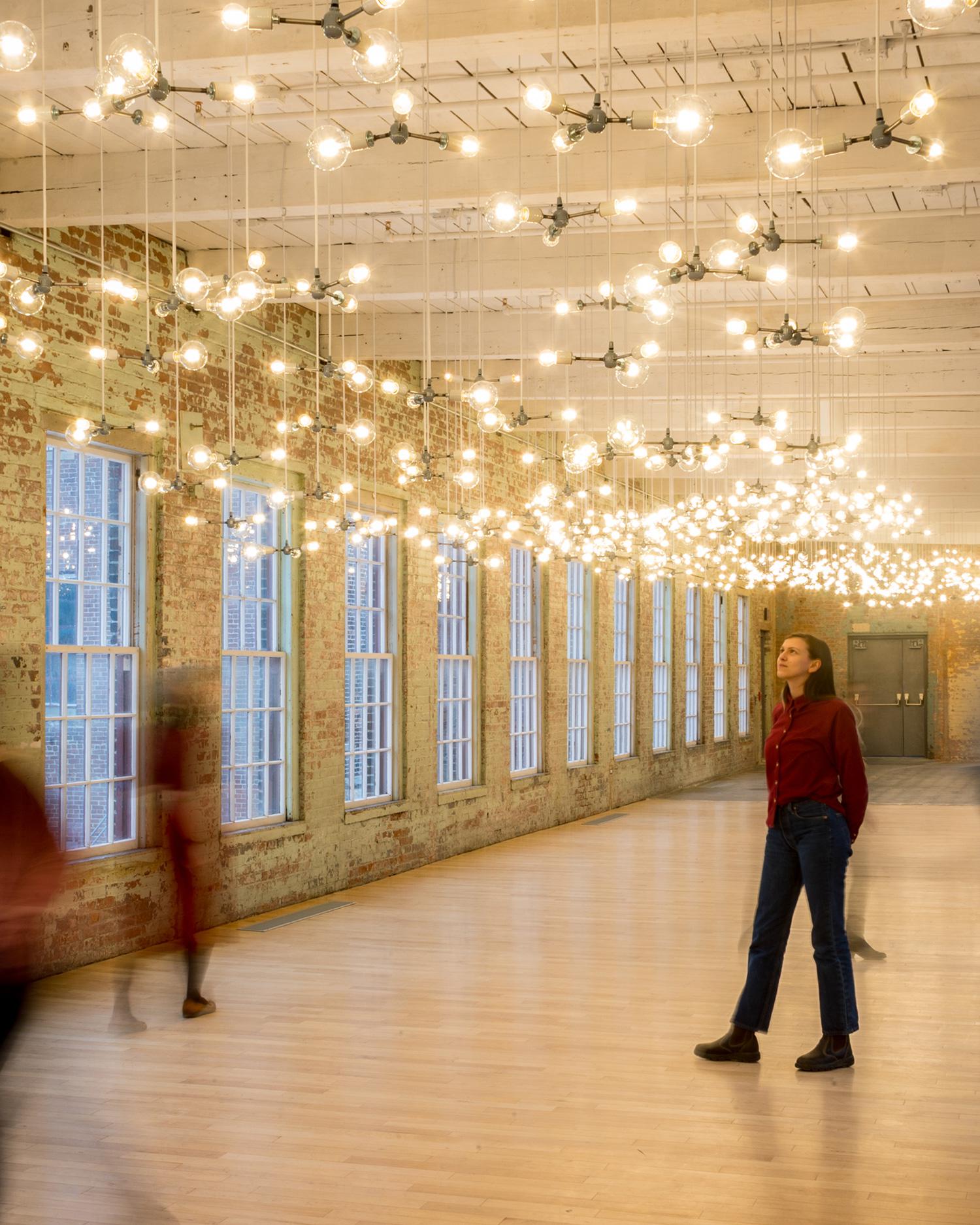 A woman walking through the Massachusetts Museum of Contemporary Art.