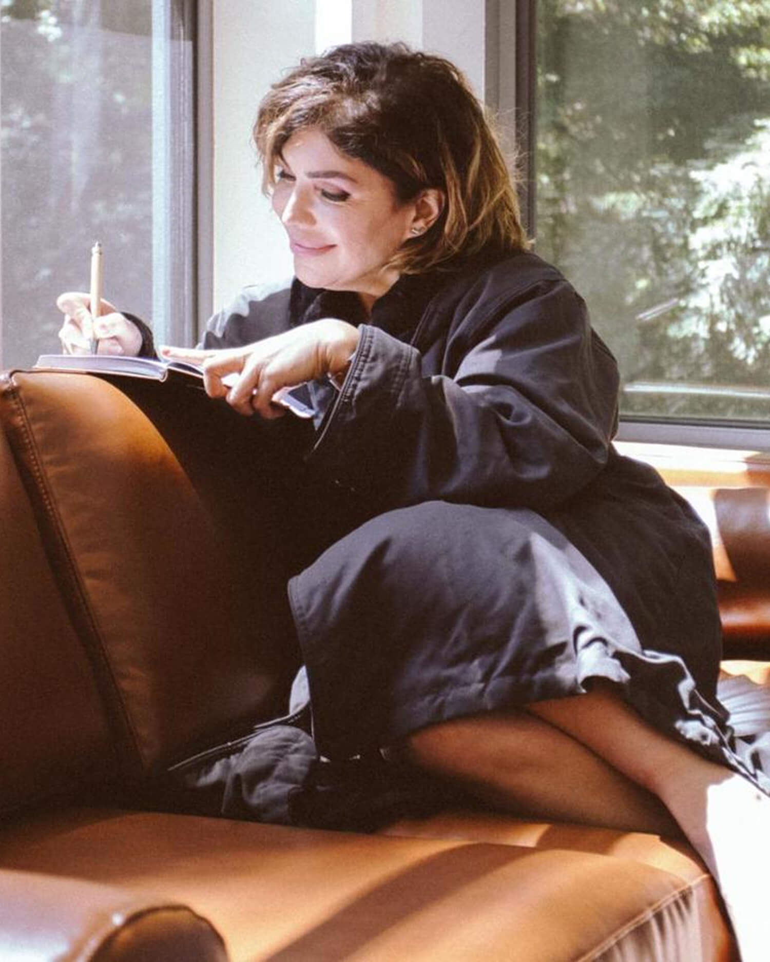 A woman journaling on a couch