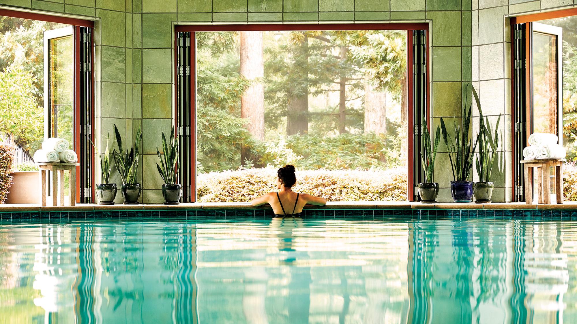 Woman in a swimming pool looking out to nature.
