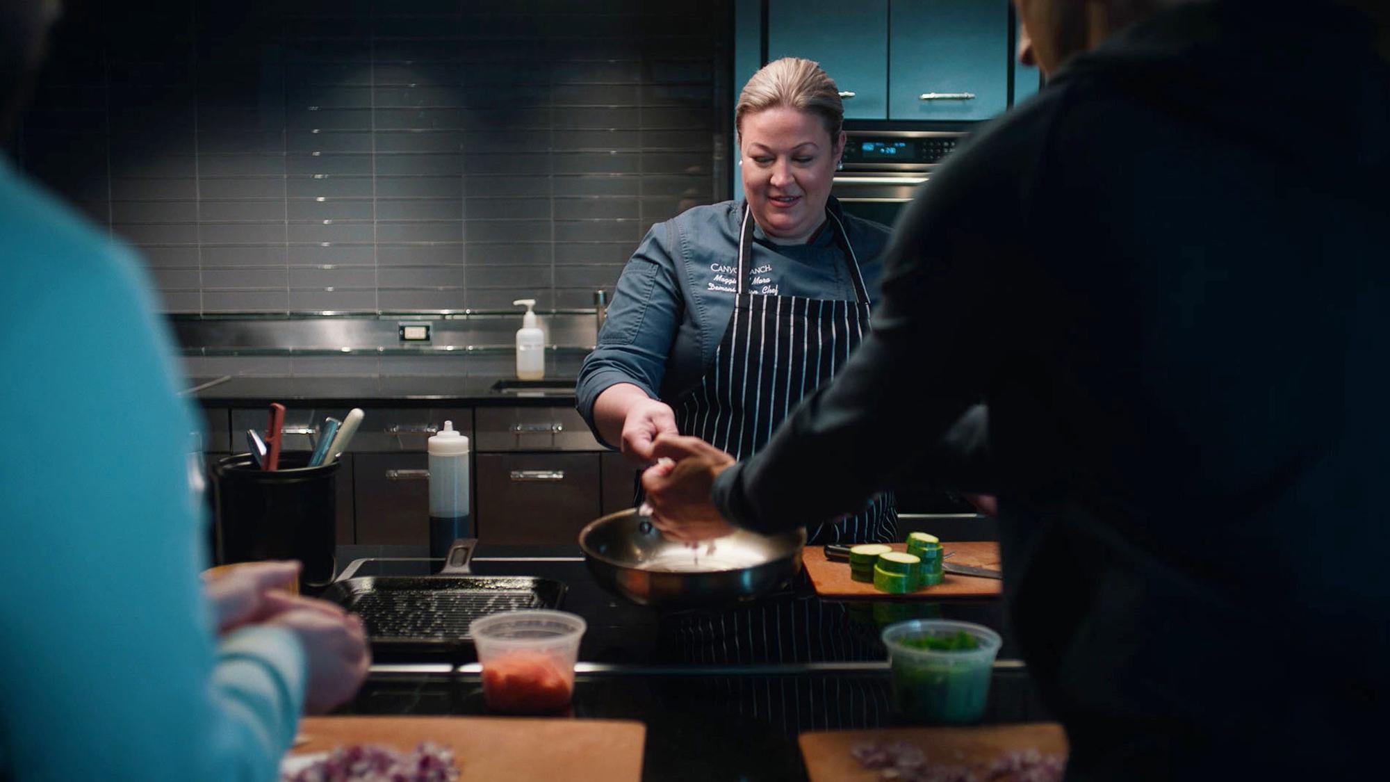 Photo of Chef in Demo Kitchen with Guests.