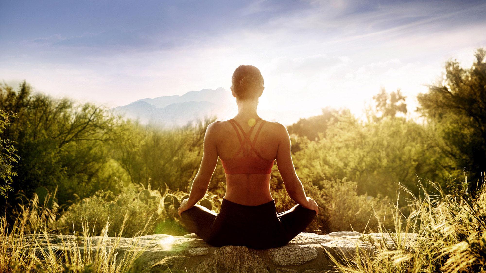 Woman practicing yoga at sunrise.