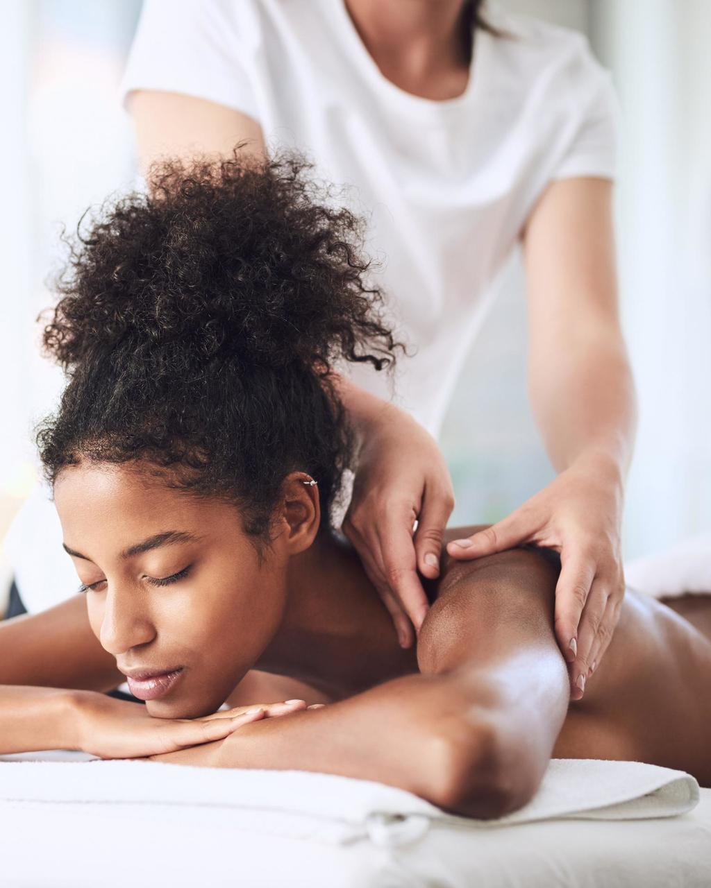 a woman getting a massage at the Fort Worth Wellness Club + Spa