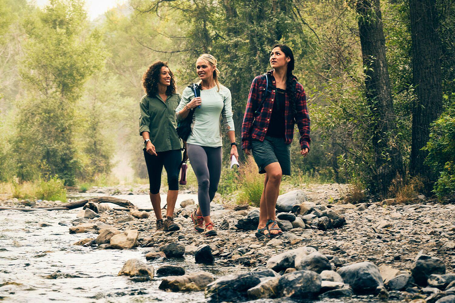 An image of women hiking by a forest stream at Canyon Ranch Fort Worth Health Resort