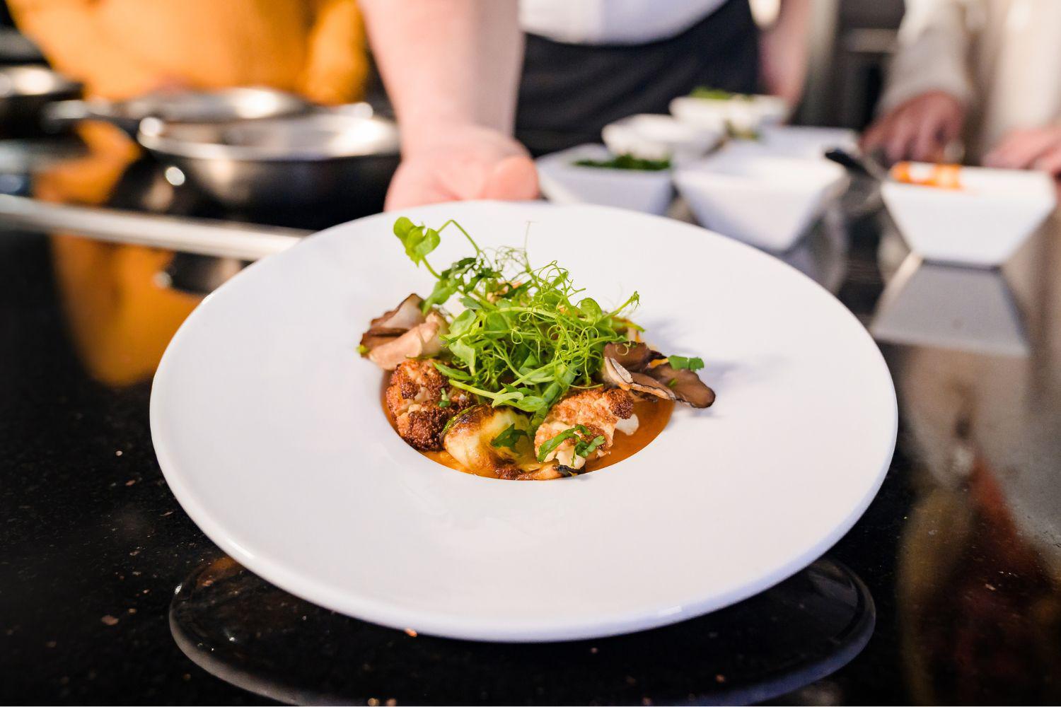 A plate of grilled shrimp held by chef nicole loeb at Canyon Ranch Lenox Health + Spa Resort