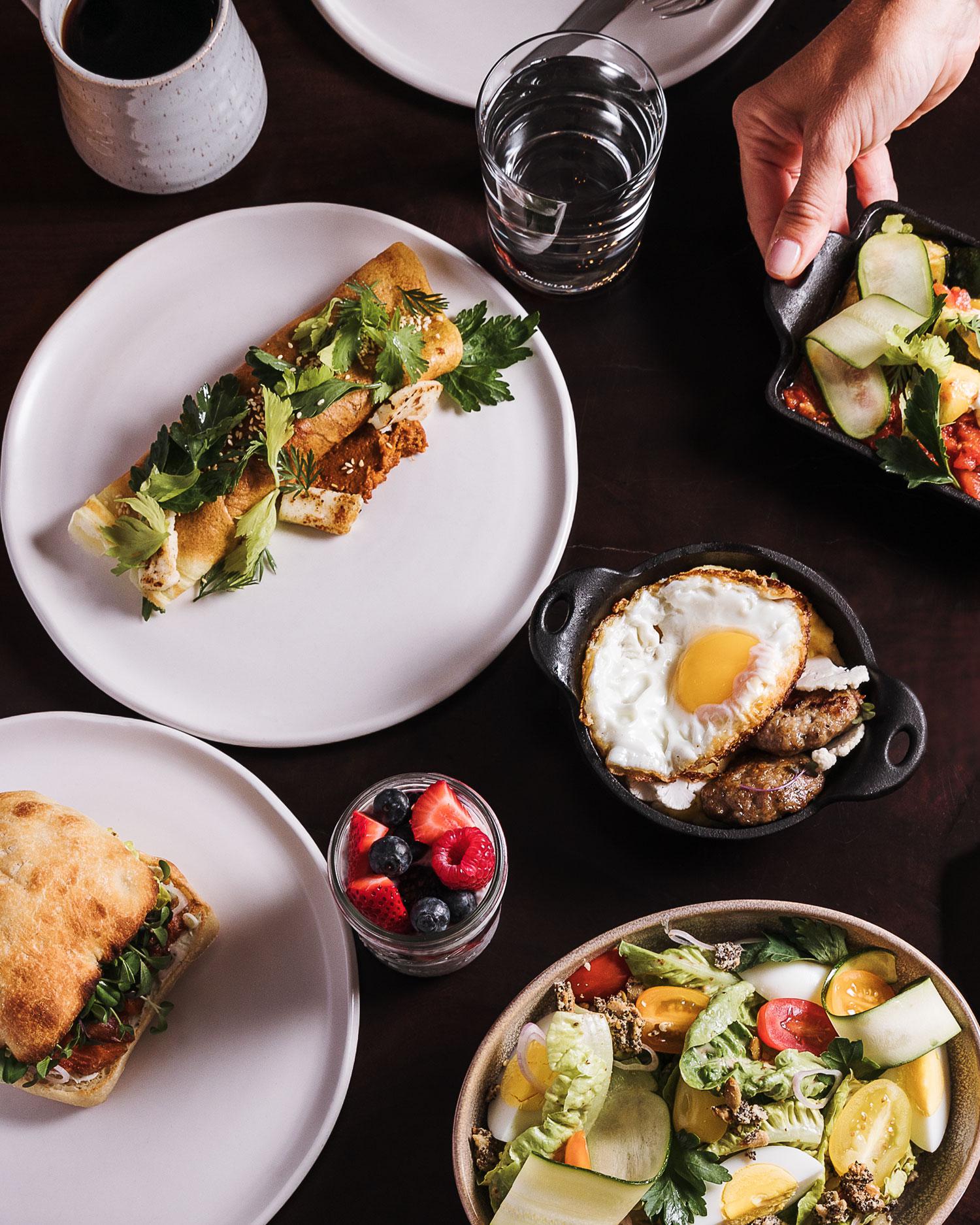 A meal with various dishes of fruits, vegetables, and proteins