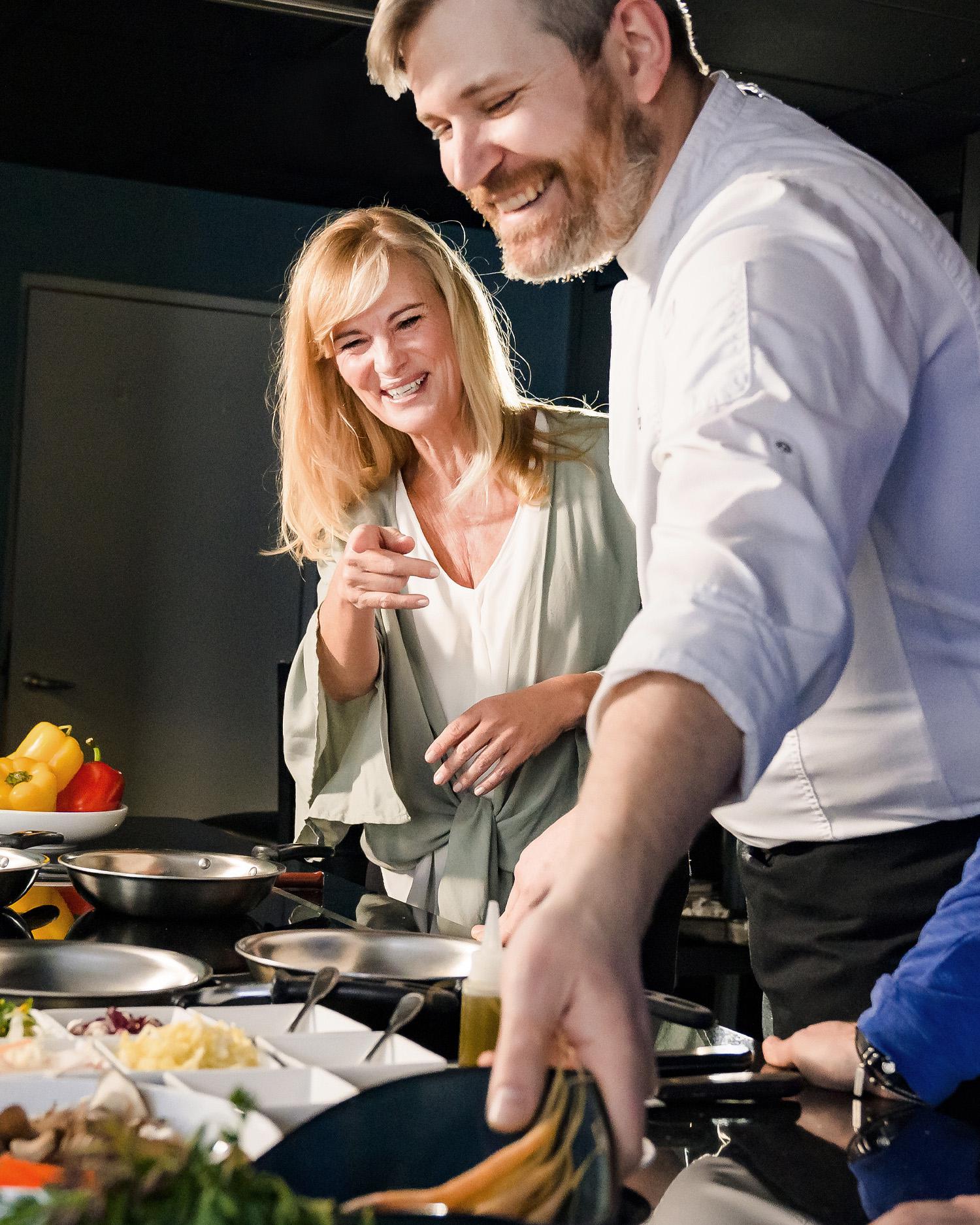 Image of a Chef working with a woman during a private cooking class.