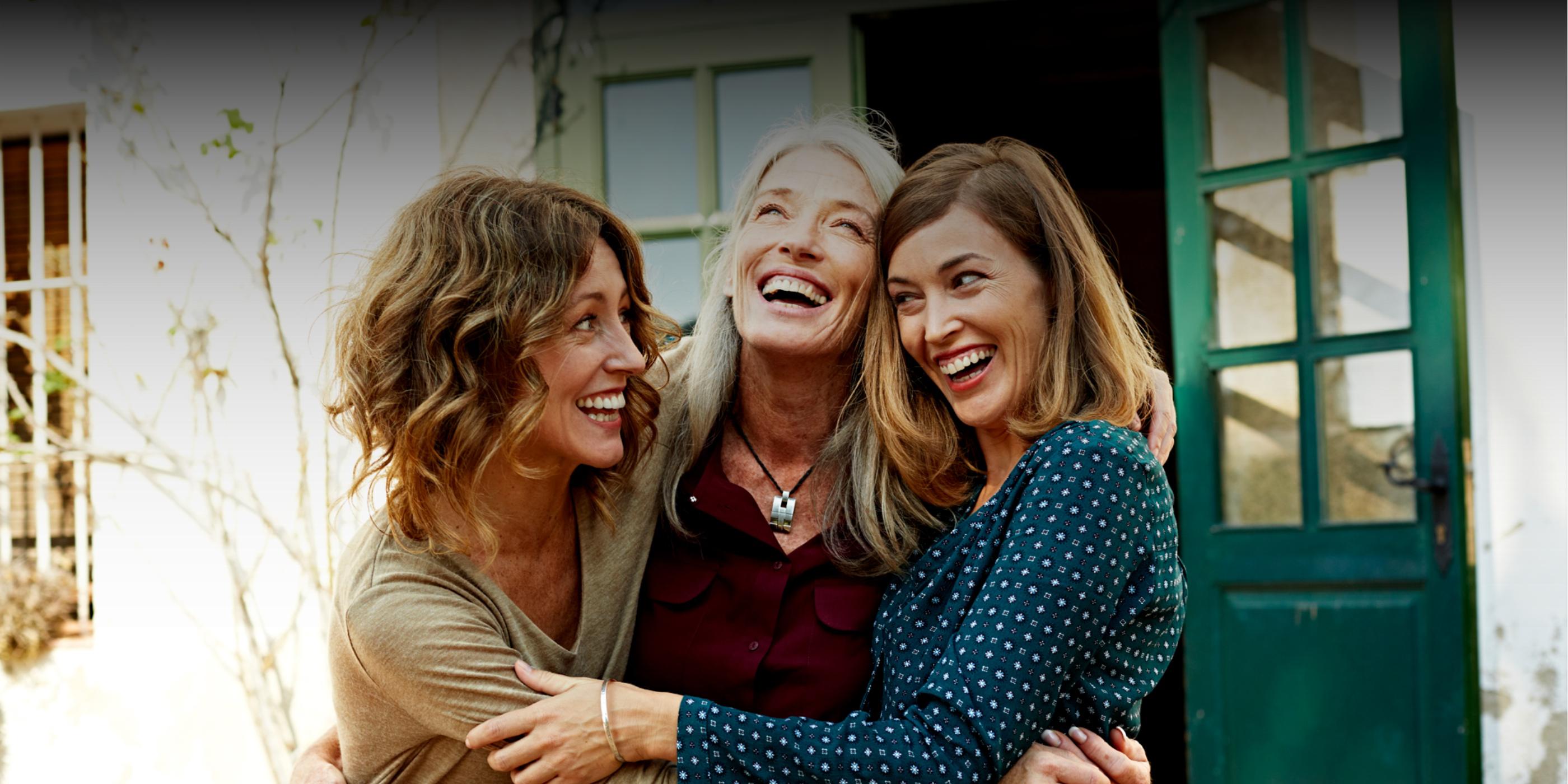 Mother and two daughters smiling and hugging