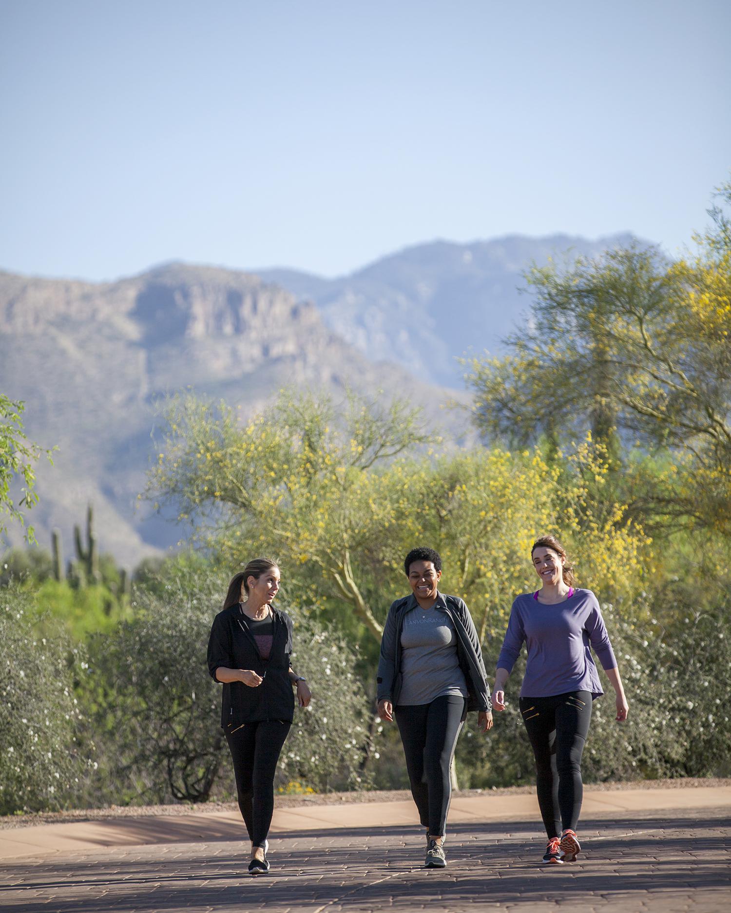 Three women walking on a desert hiking trail at Canyon Ranch Tucson