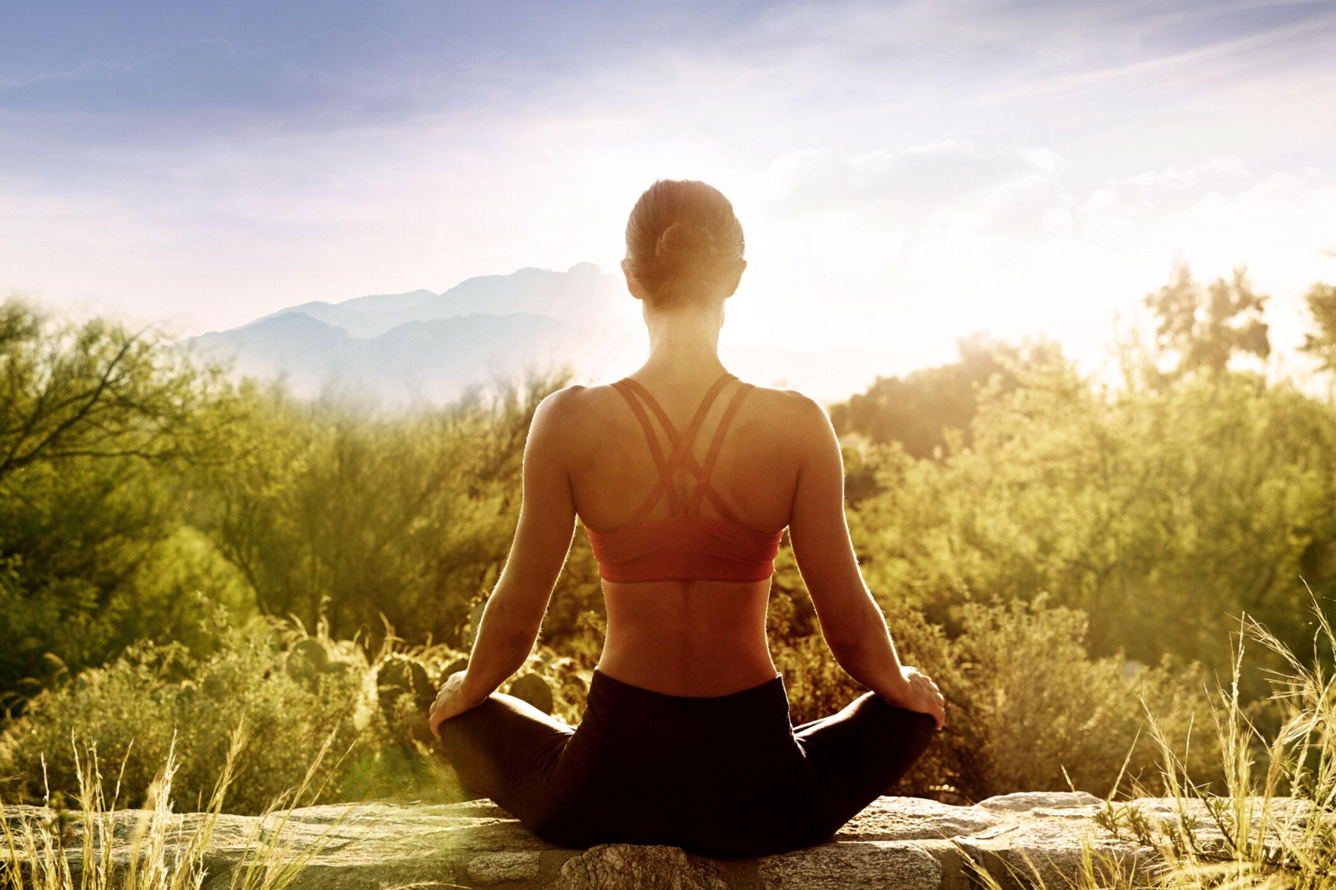 Woman doing sunrise meditation in the Sonoran Desert