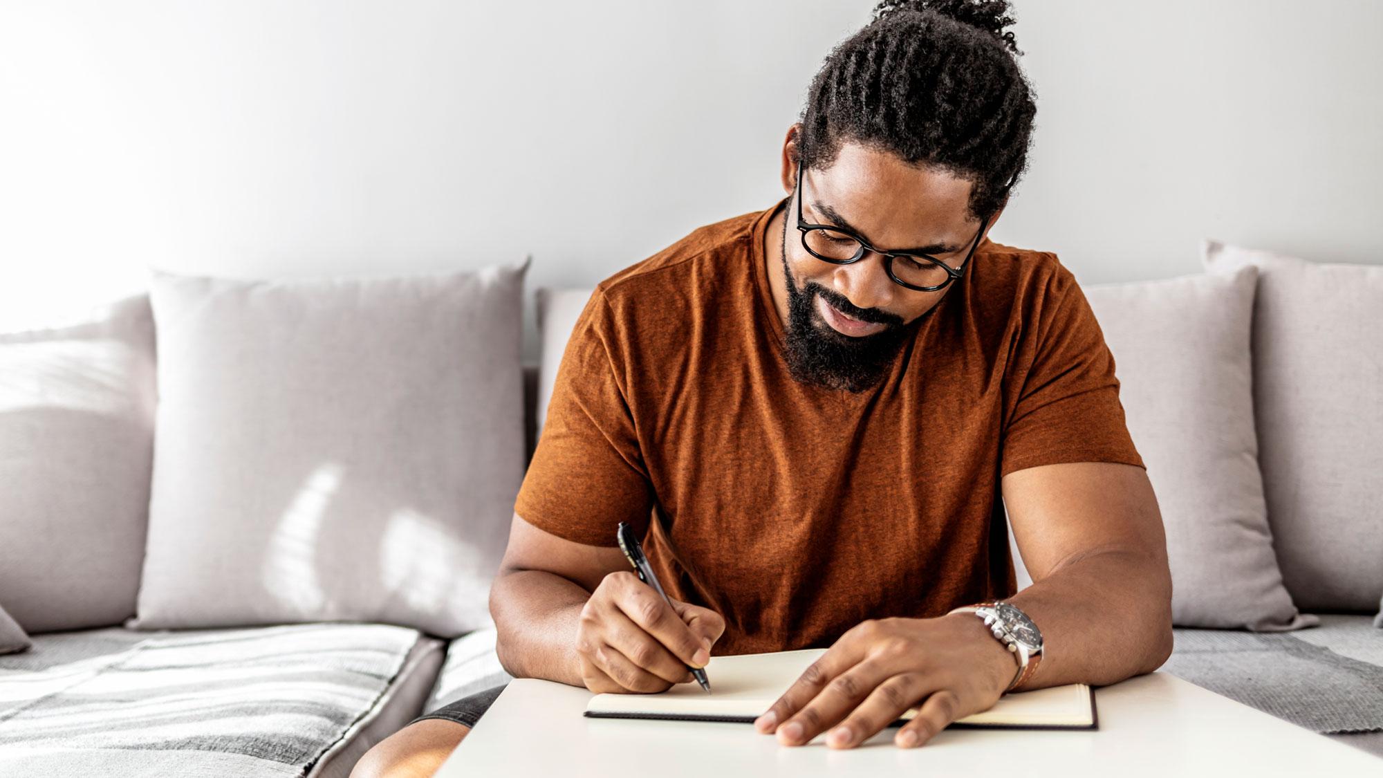 man journaling in cozy room  