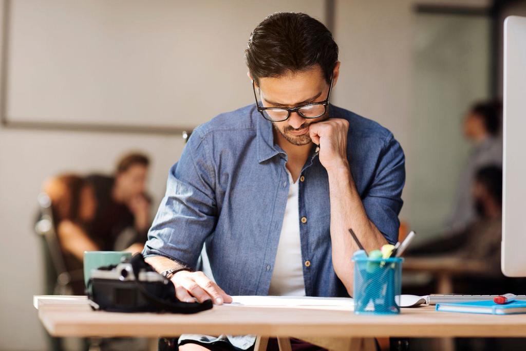 A man looking a papers on his desk