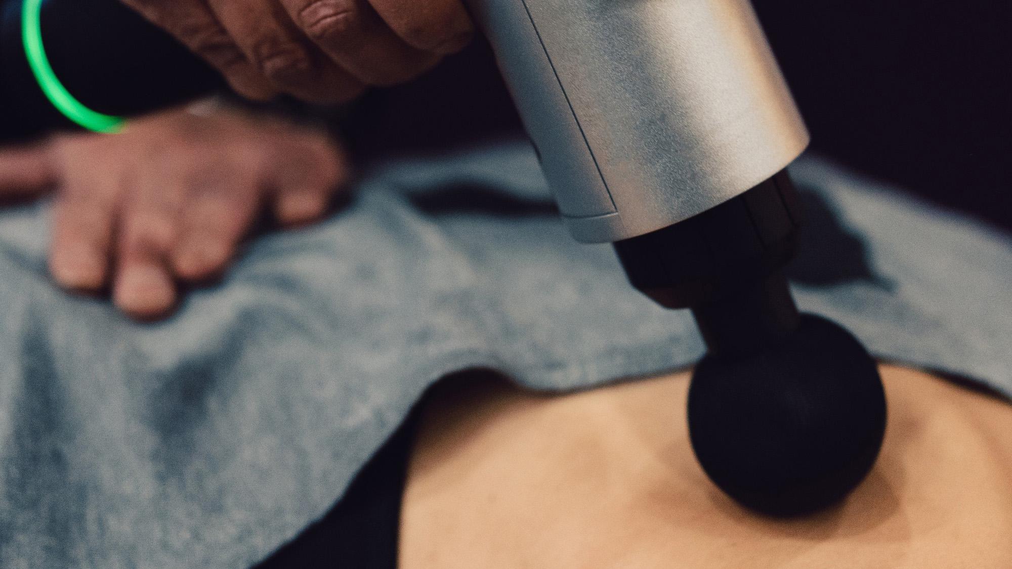 A percussion device being used on a person's back.