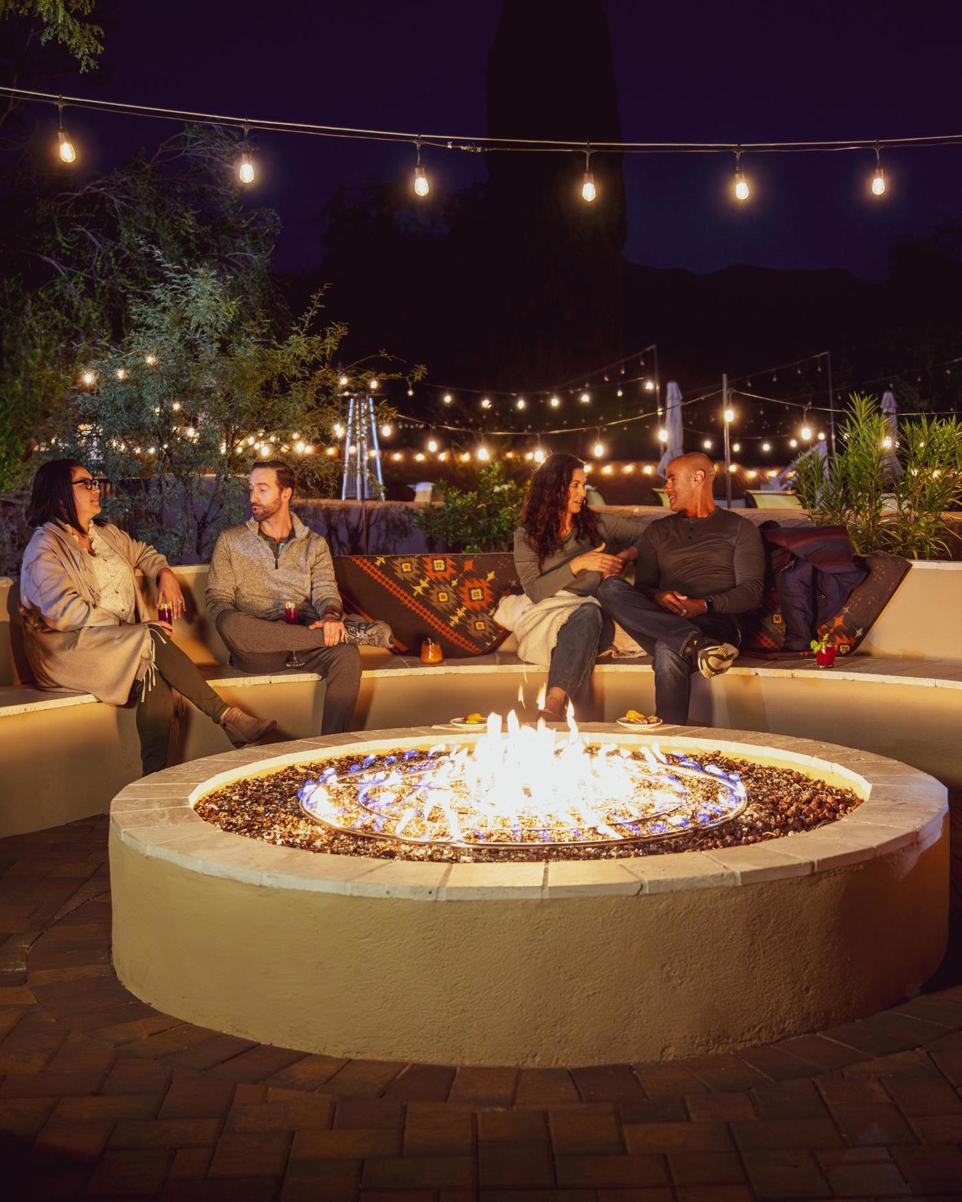 An image of people drinking wine at the fire pit