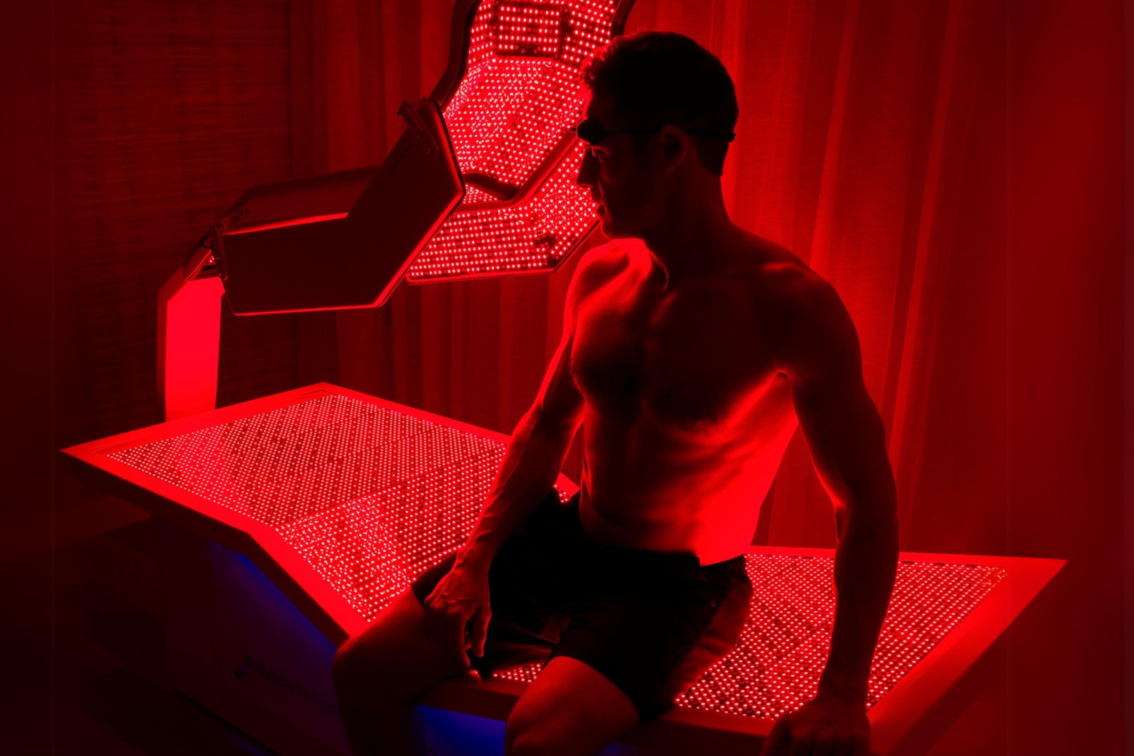 A man on a red light therapy bed