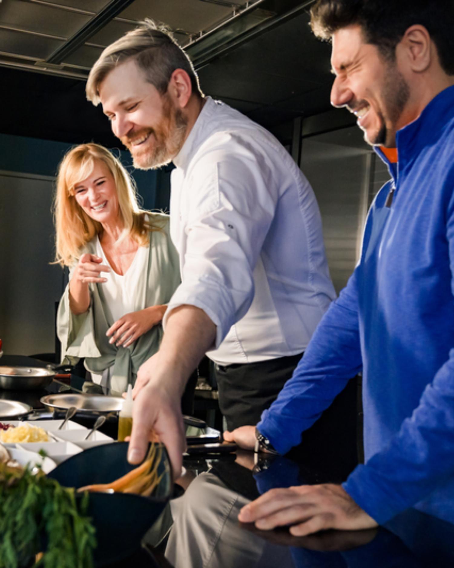 A couple taking a cooking lesson in the demo kitchen in Canyon Ranch.