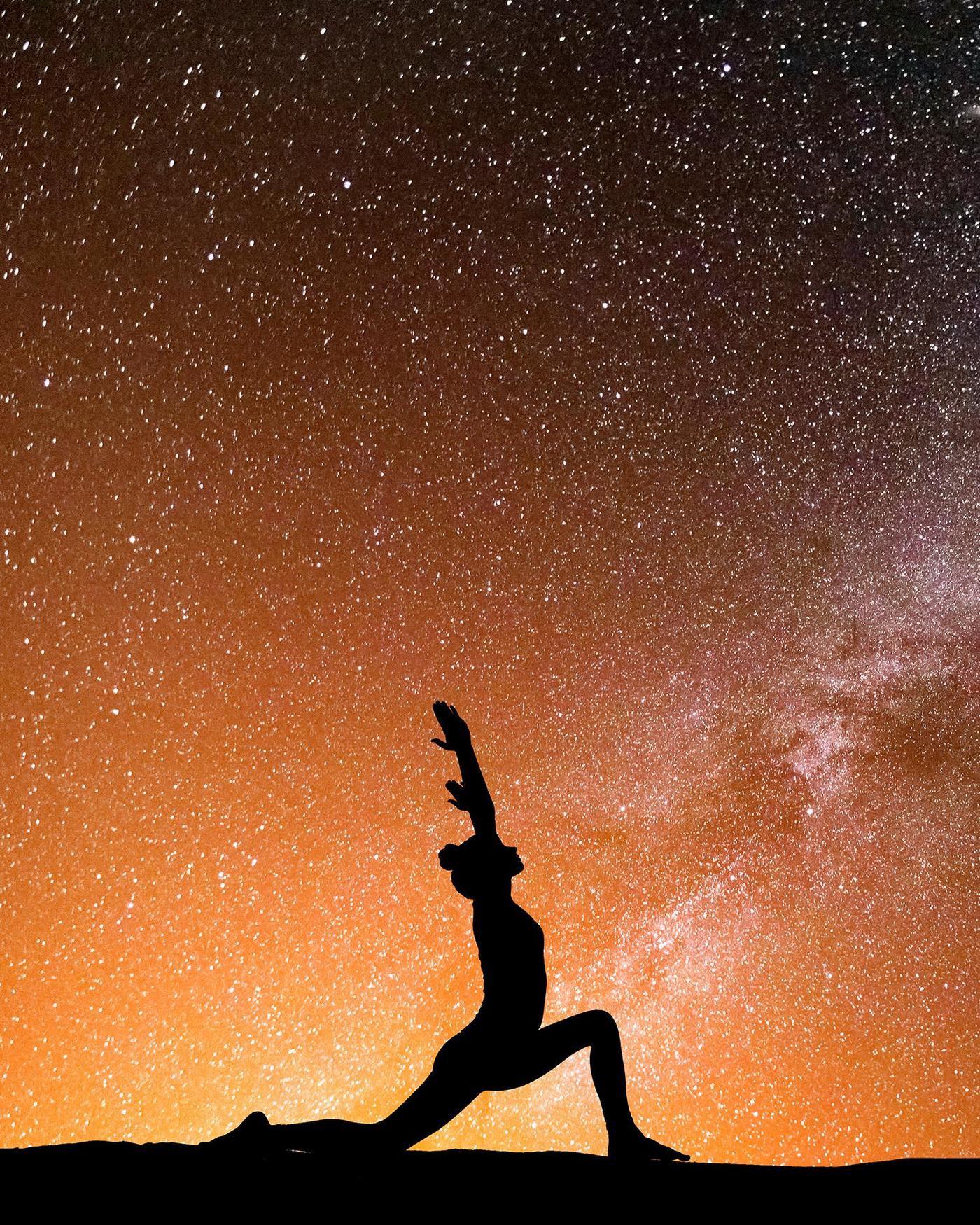 A woman doing yoga under the stars