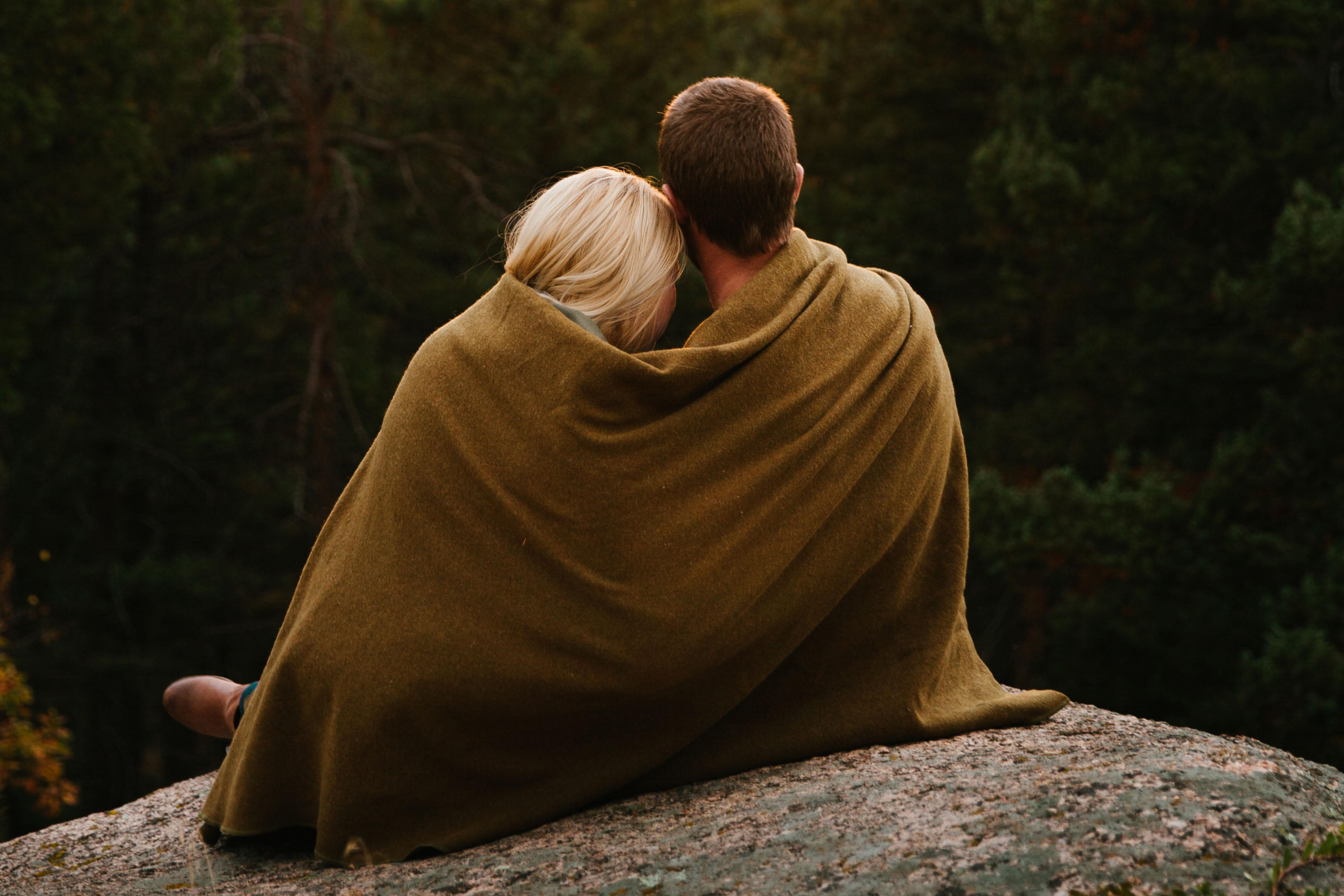 a couple cuddling under a blanket