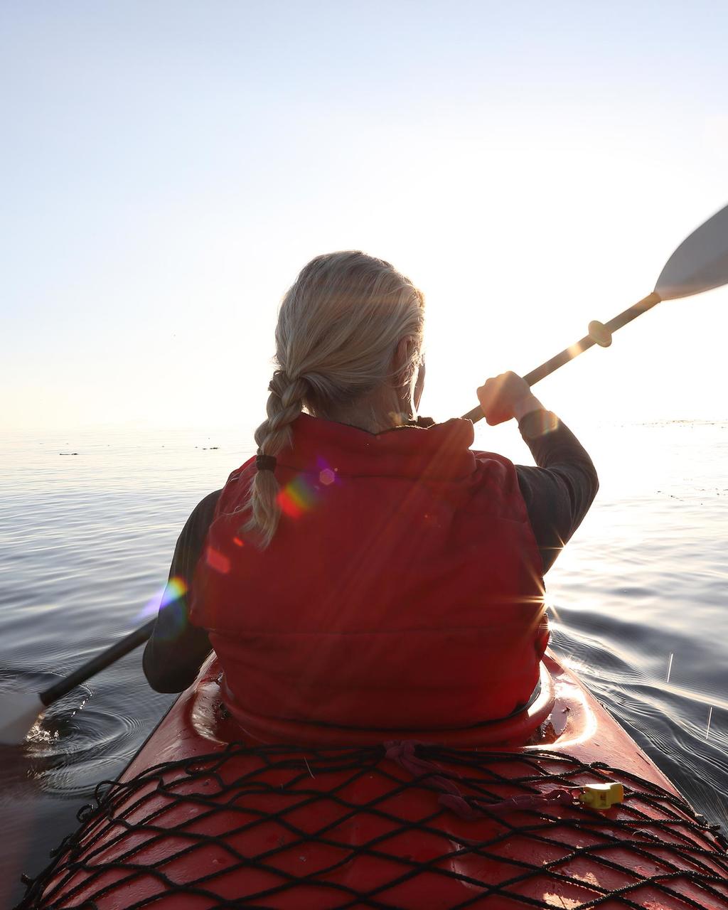 a woman kayaking in Half Moon Bay guided by Canyon Ranch Woodside Fitness + Spa 