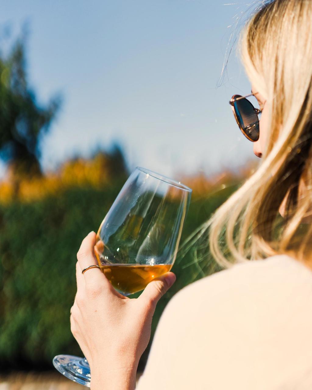a woman drinking a glass of wine at the Thomas Fogarty Winery near Canyon Ranch Woodside Fitness + Spa Resort