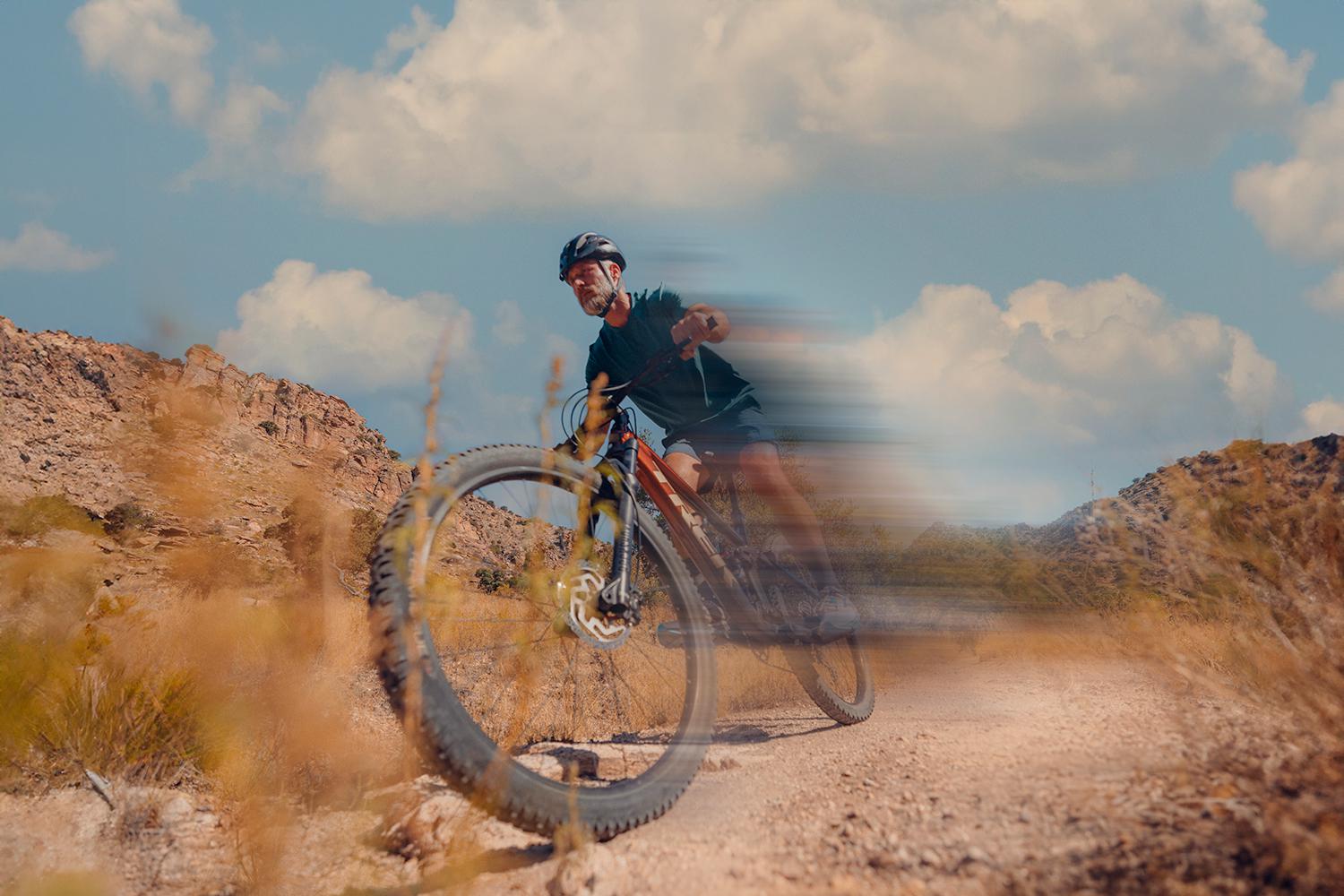 A man riding a bike in the desert