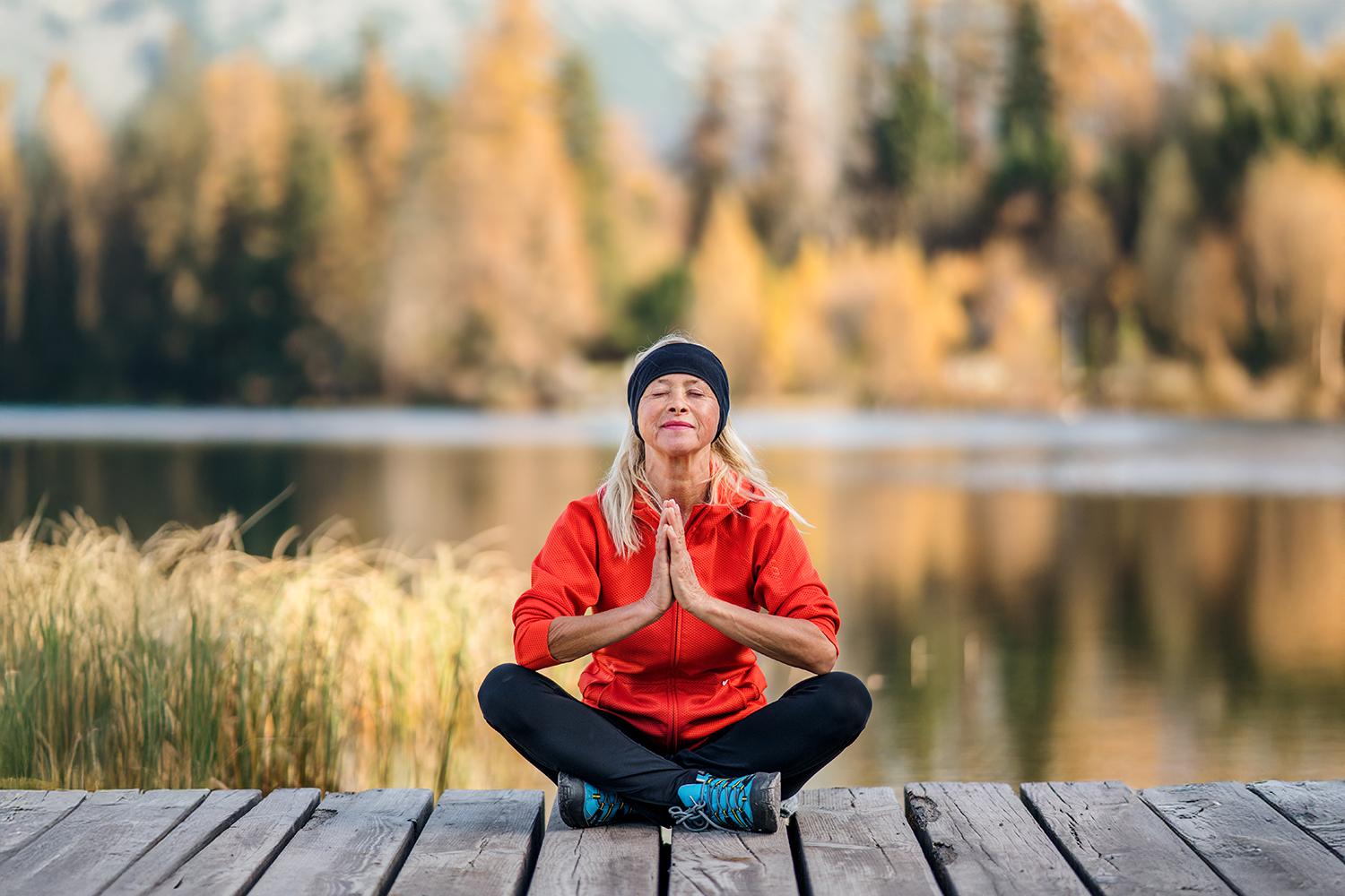 A woman meditating on a dock