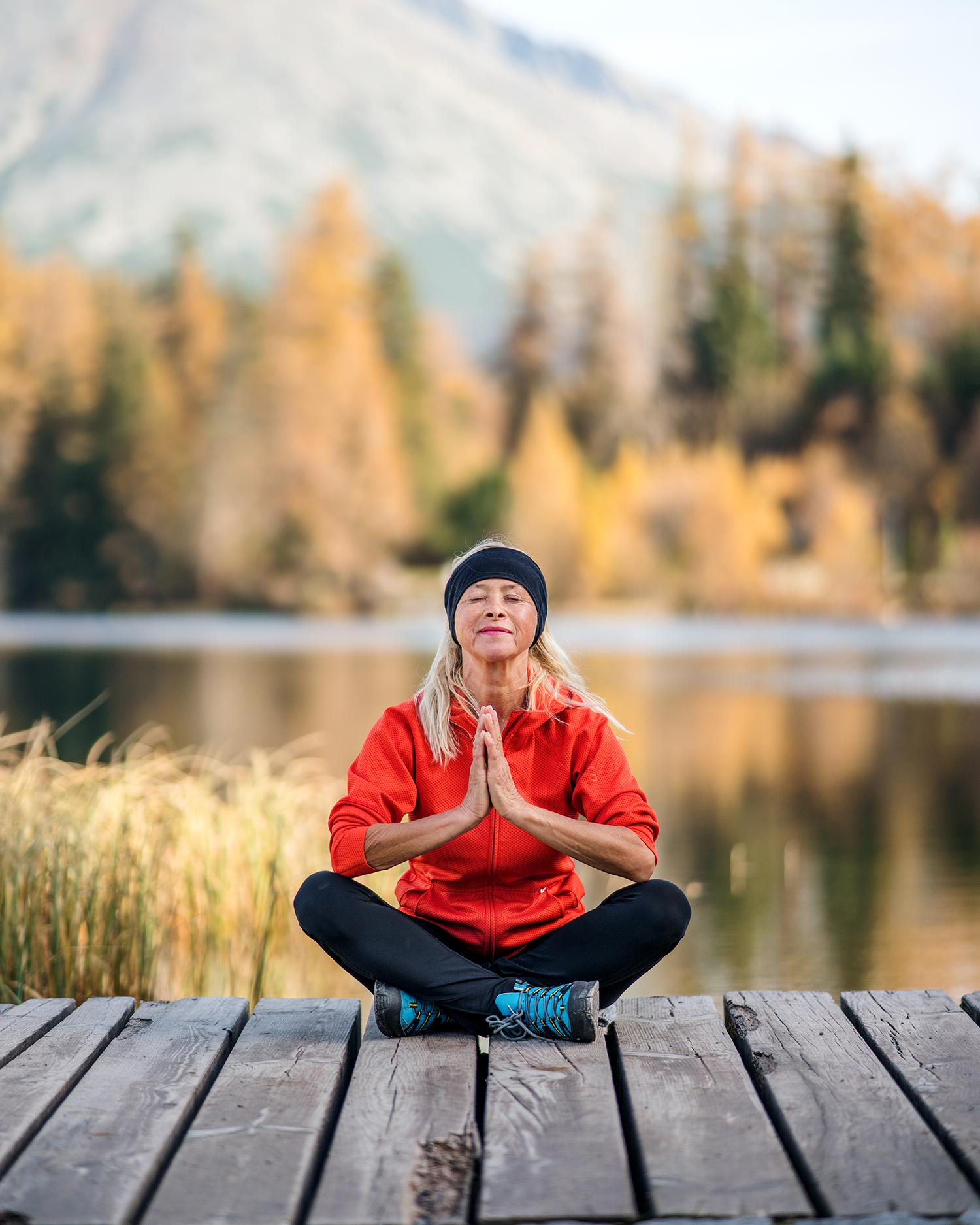 A woman meditating on a dock