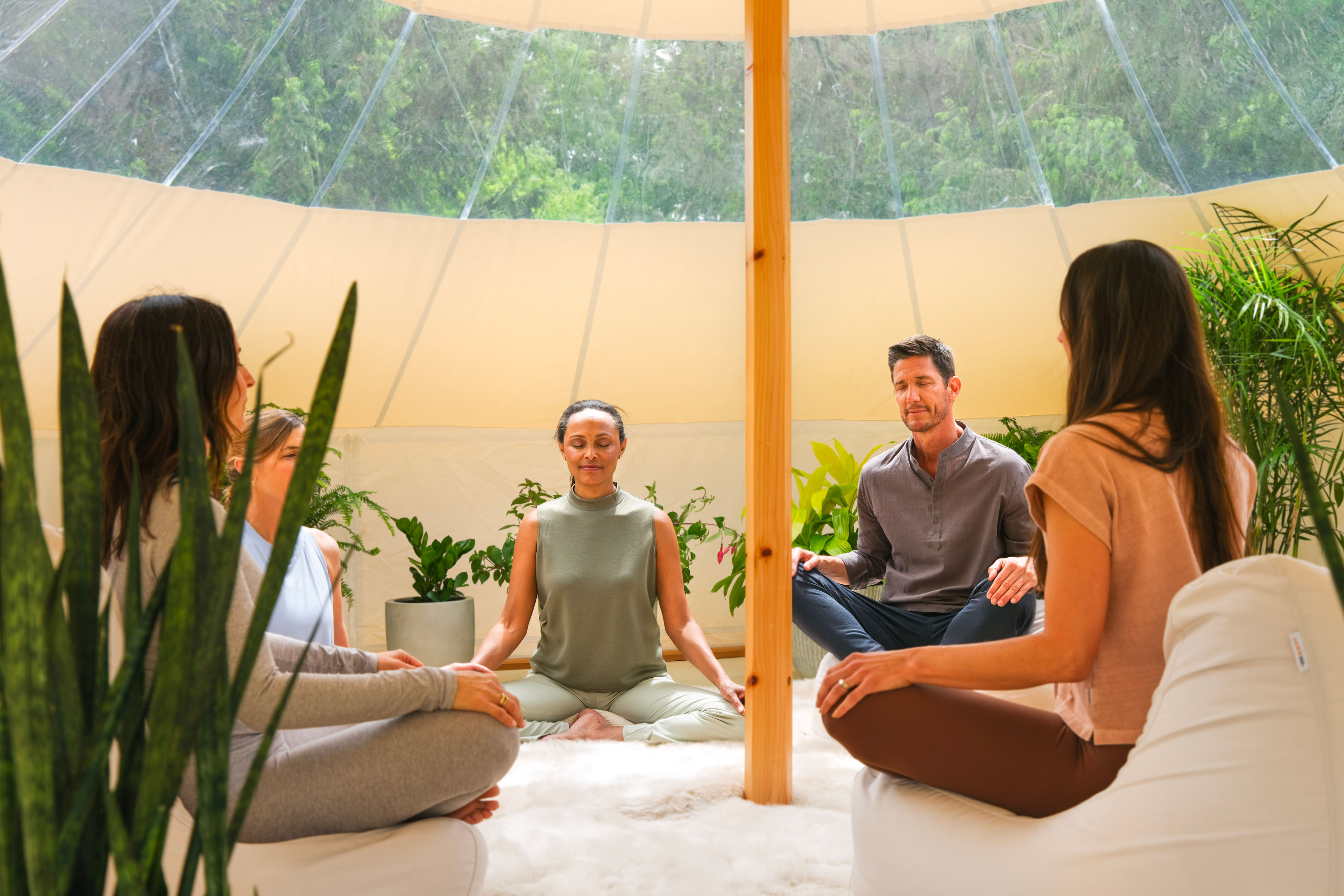 A group of people meditating in a tent