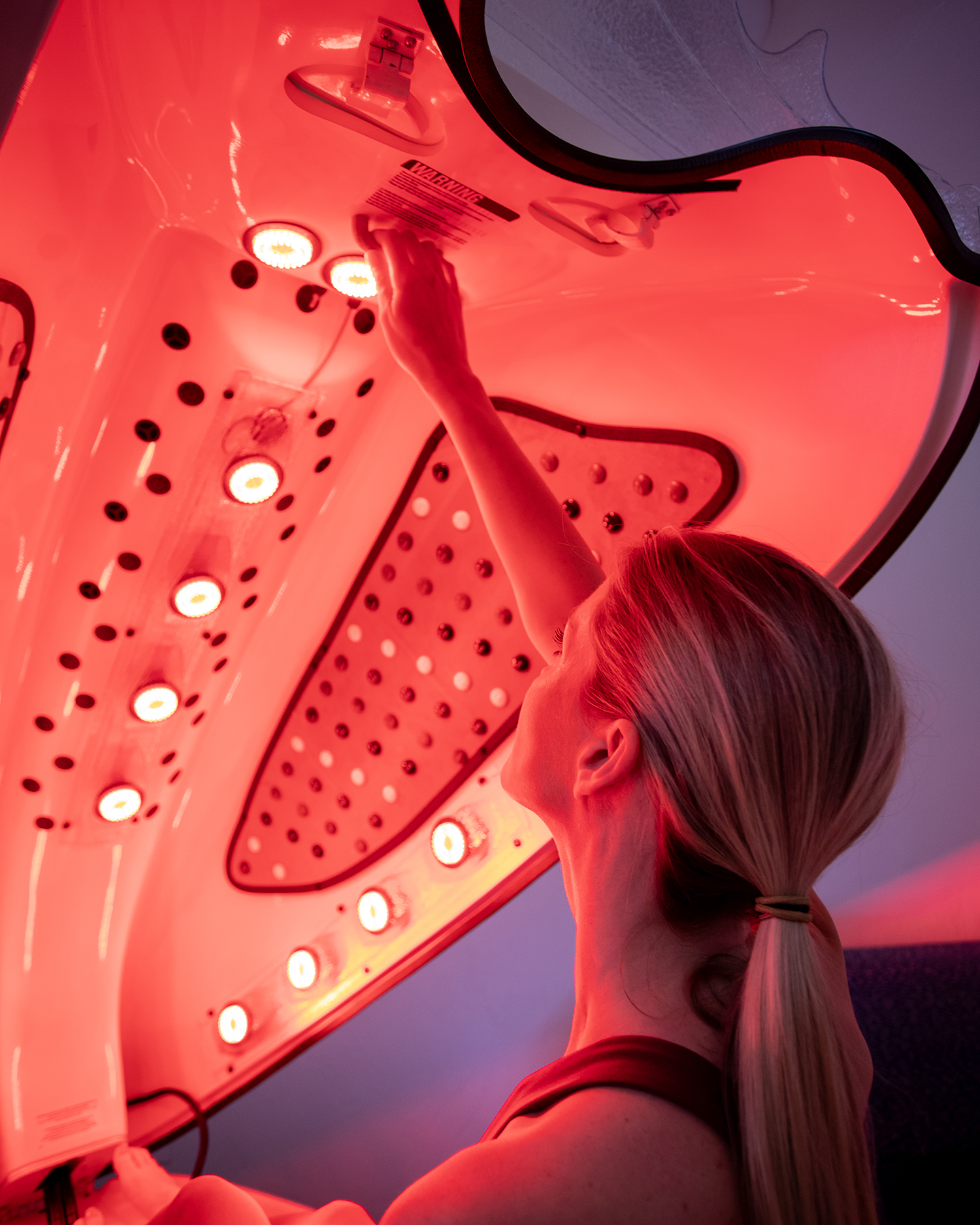 A woman in a red light therapy bed