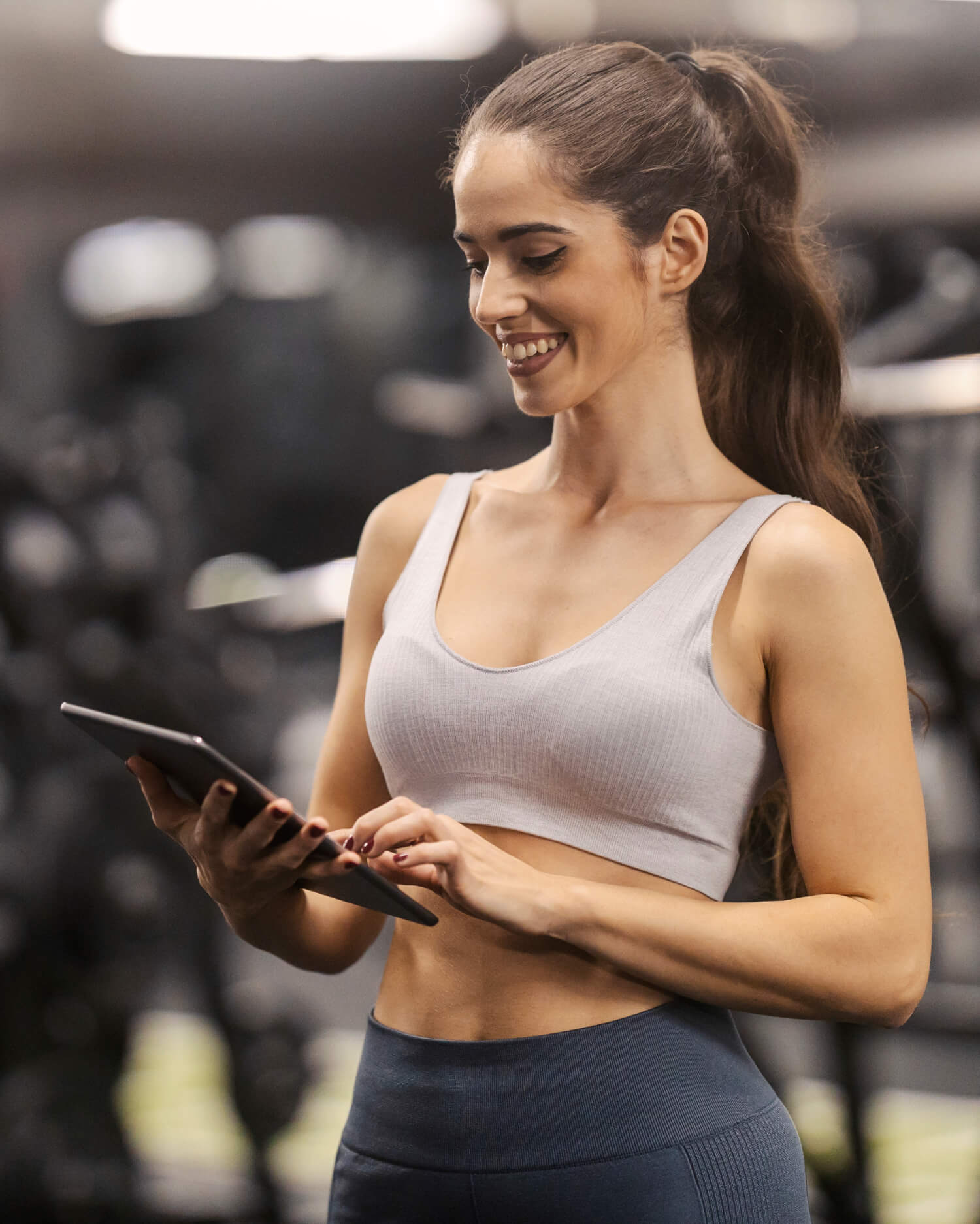 A woman with an ipad in a gym