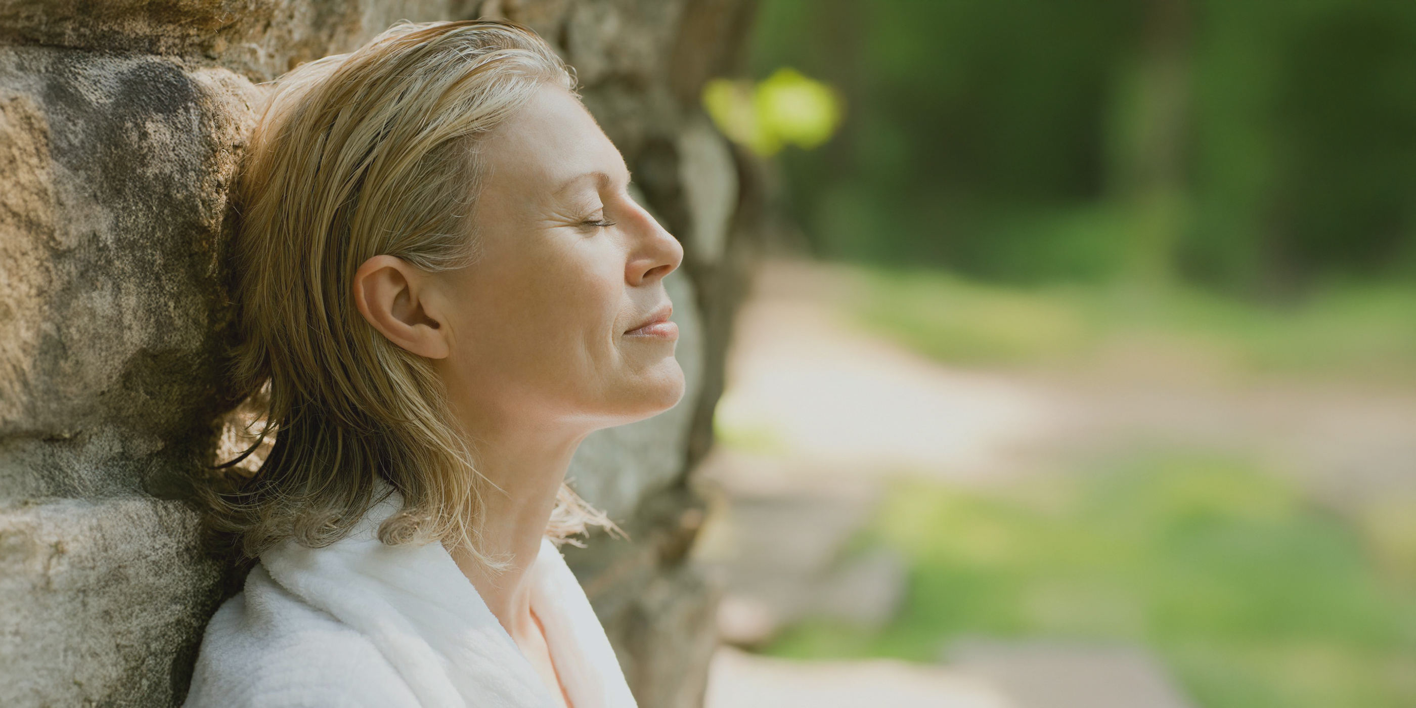 A woman leaning against a tree