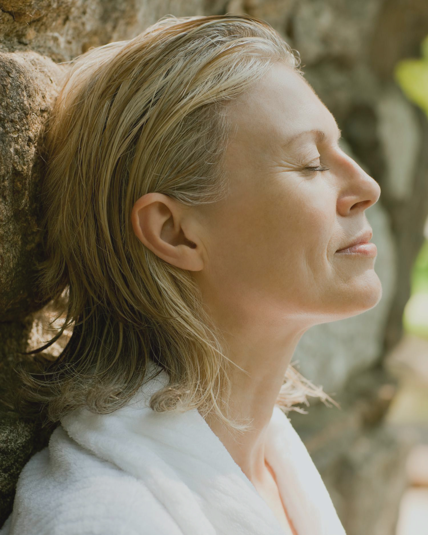A woman outdoors by a tree