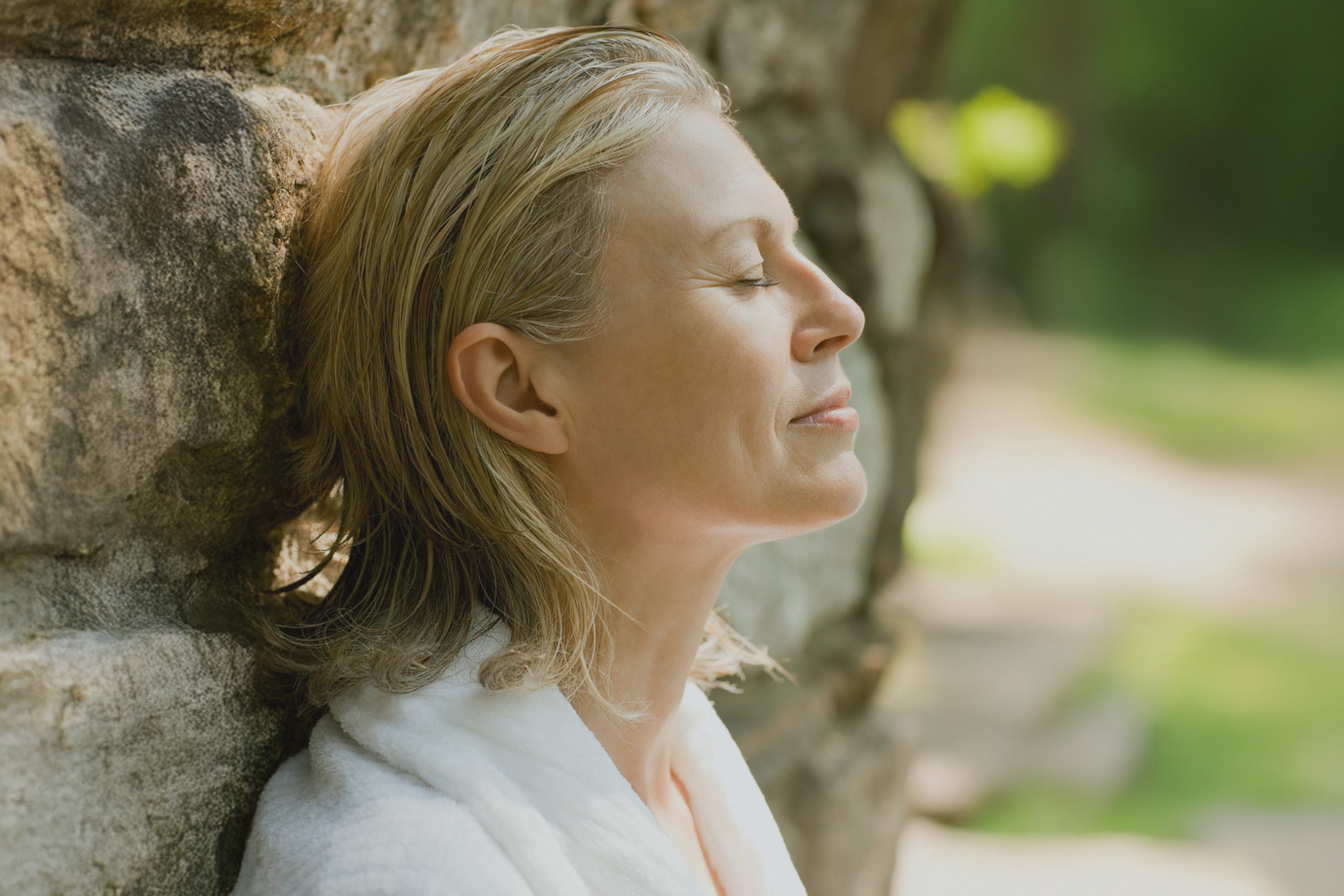 A woman leaning against a tree