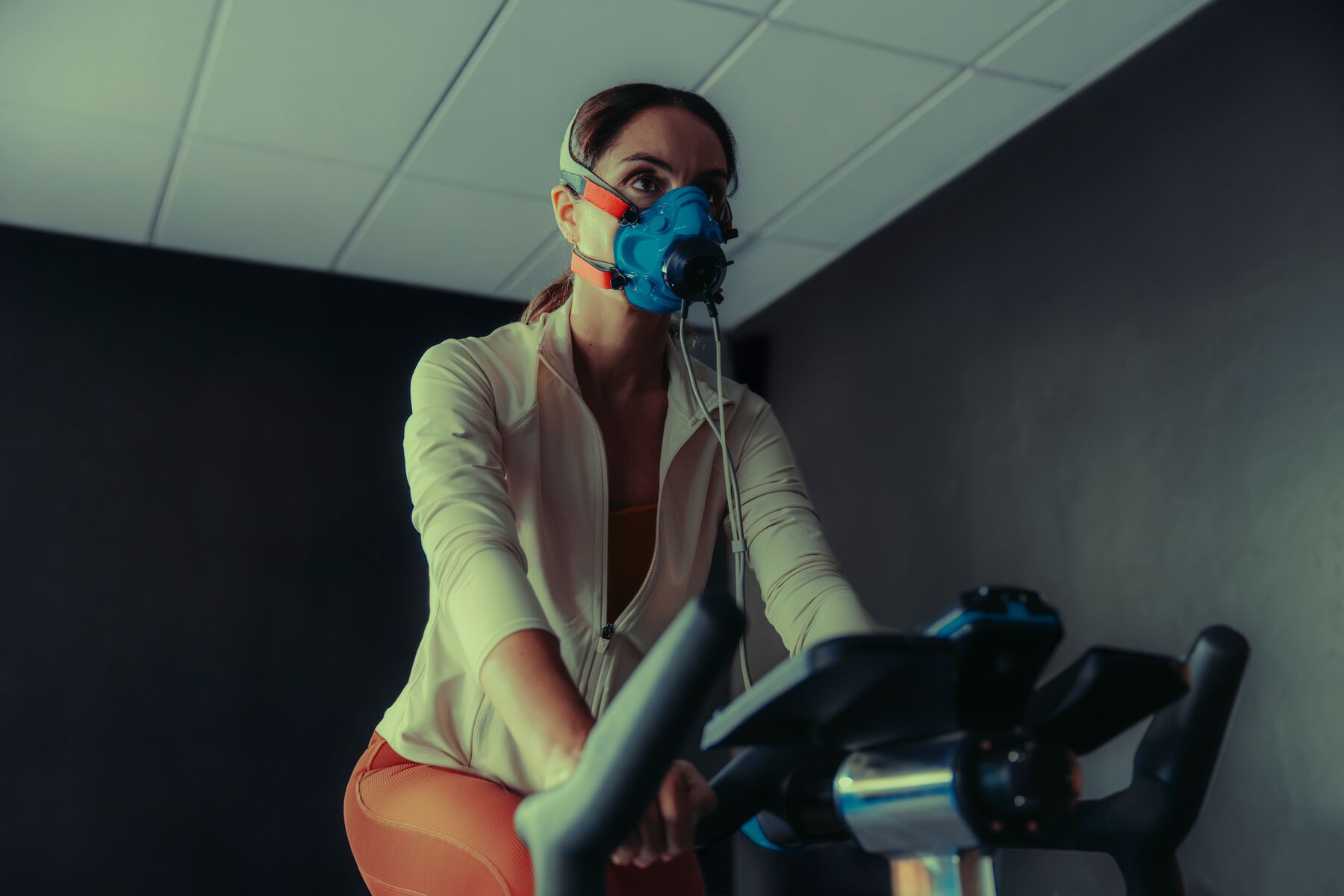 a woman running on a treadmill in a vo2 max mask
