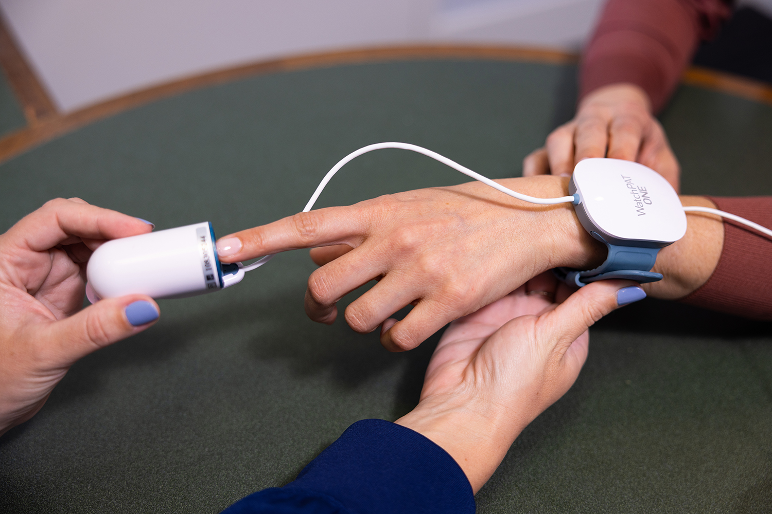 a hand with a heart monitor device