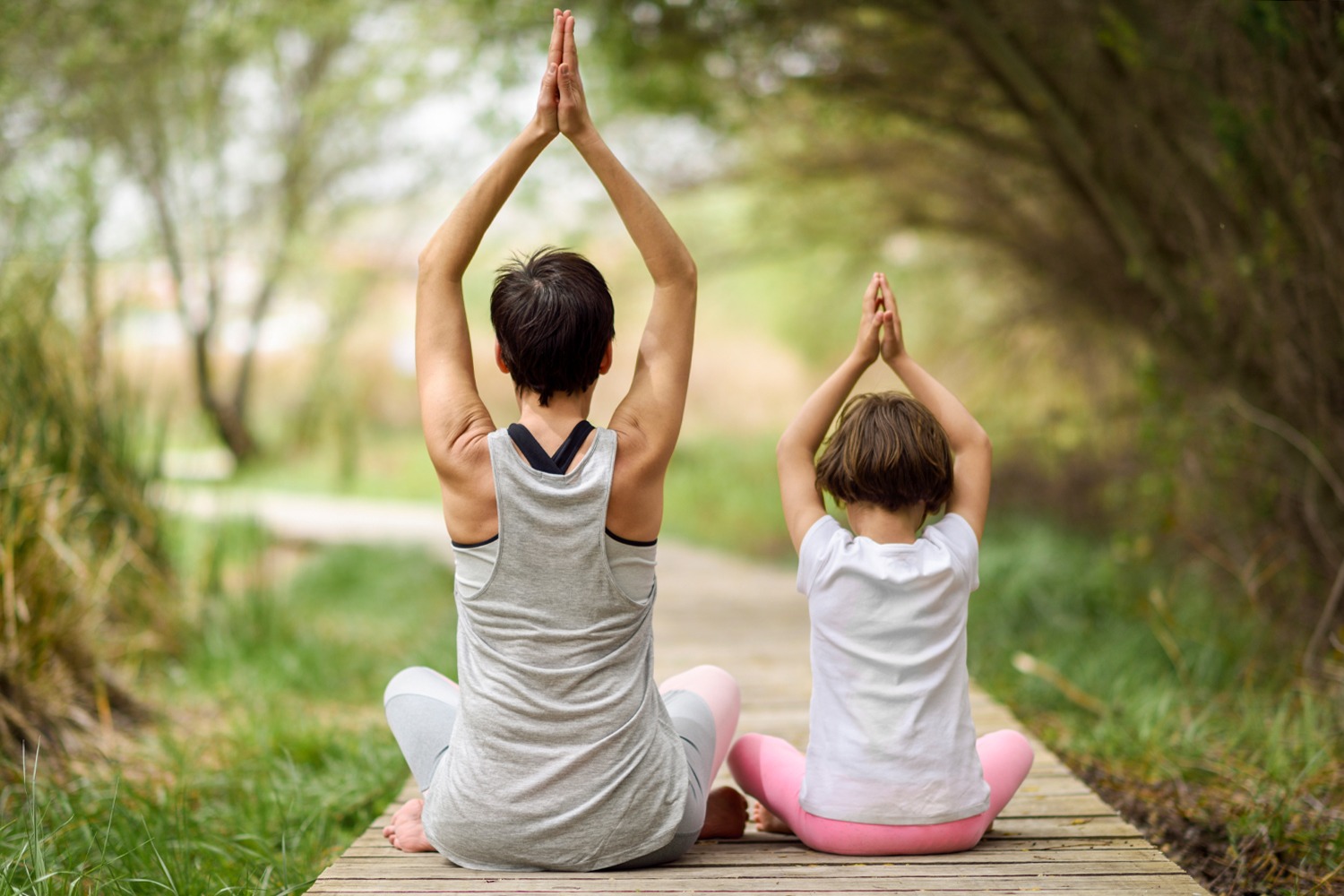 a mom and daughter doing yoga together