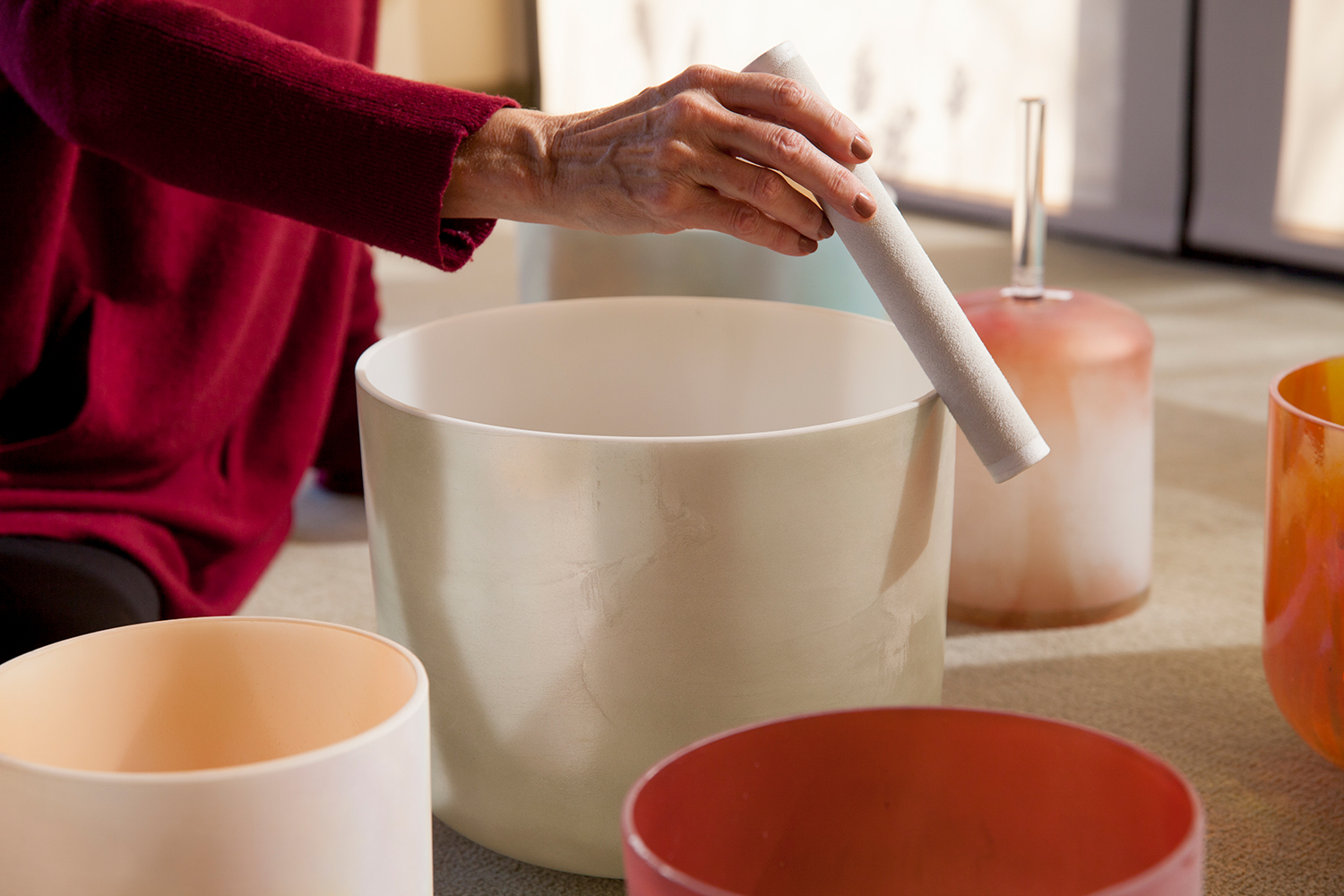 a woman playing crystal bowls