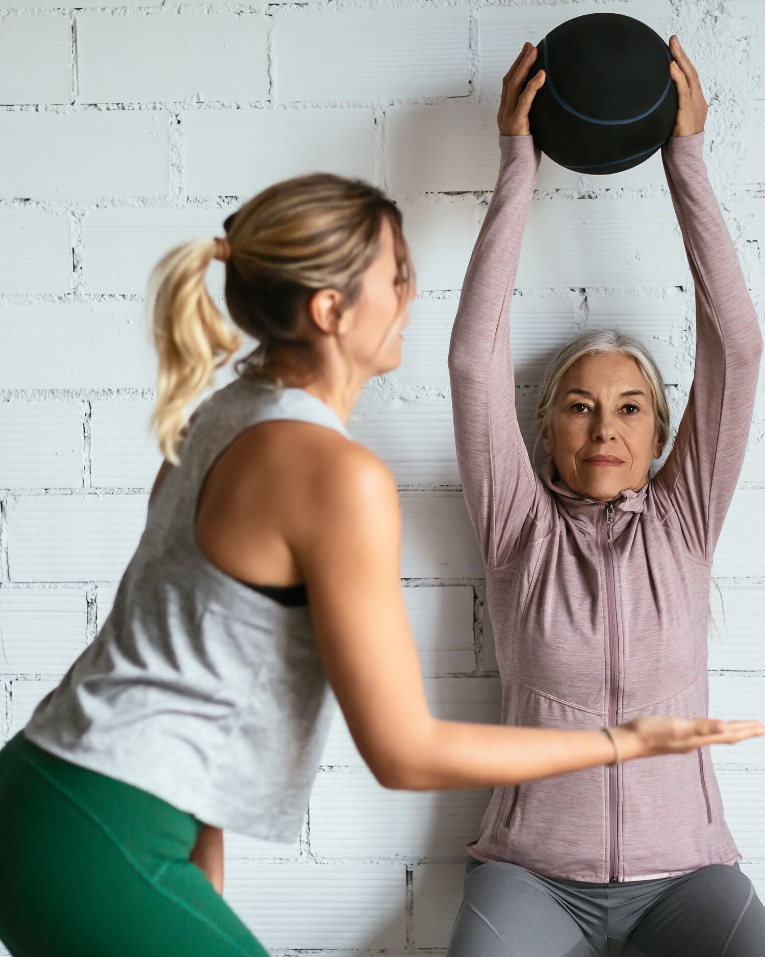 Woman Training with Medicine Ball with Fitness Instructor