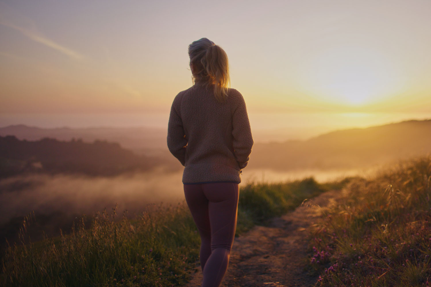 a woman walking at sunset