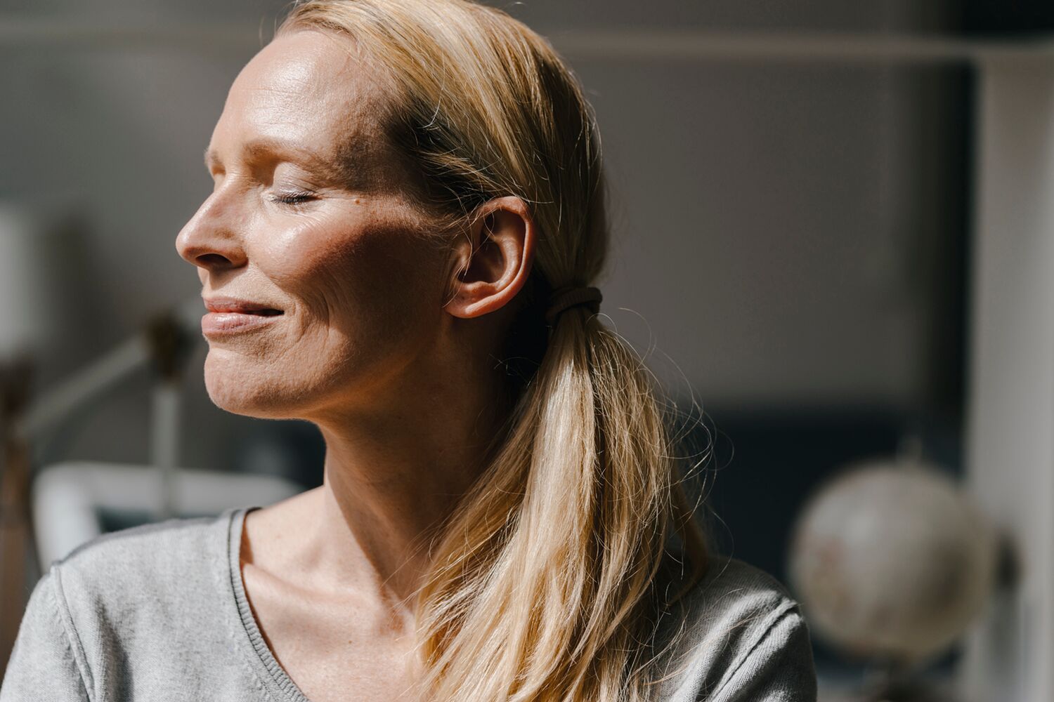 Woman Meditating Contently with Sun in Her Face 