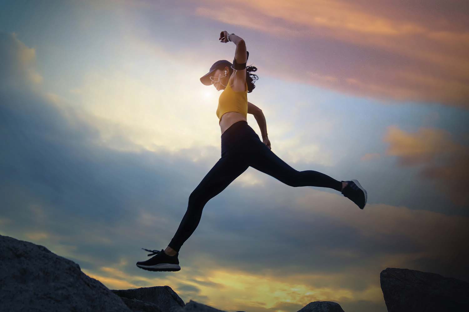 a woman jumping over a rock