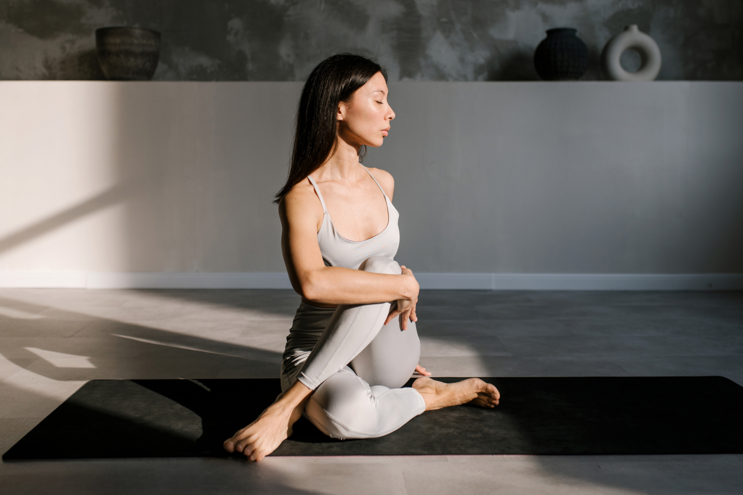 A woman wearing grey doing yoga