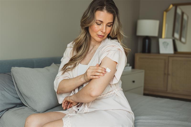 a woman applying a sticker on her leg