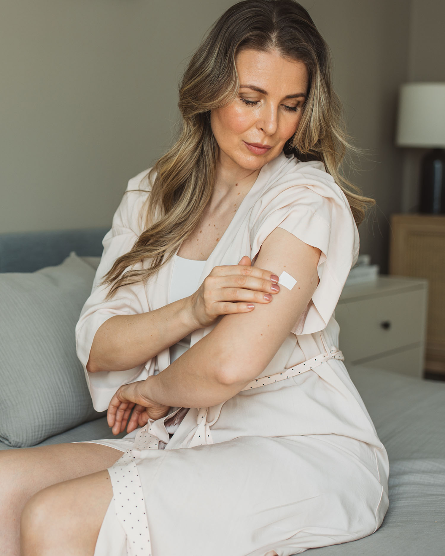 a woman applying a sticker on her leg