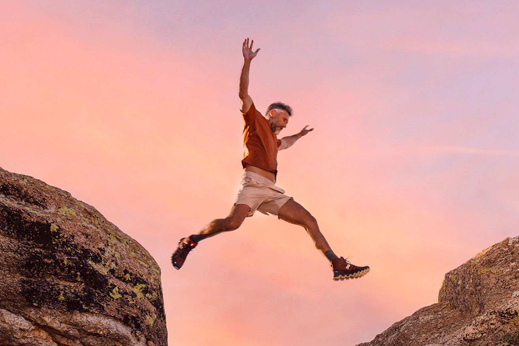 a man jumping over a rock