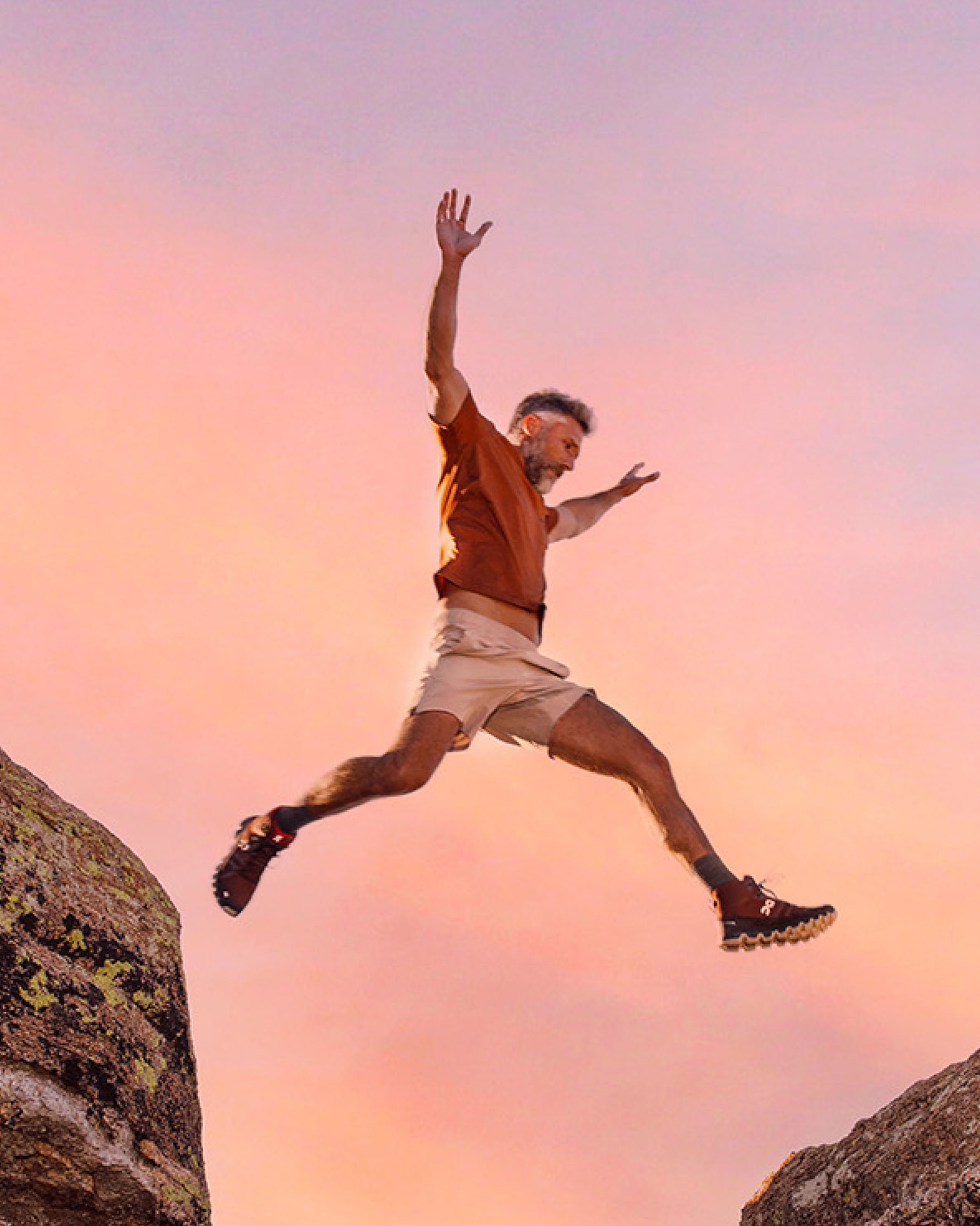 a man jumping over a rock