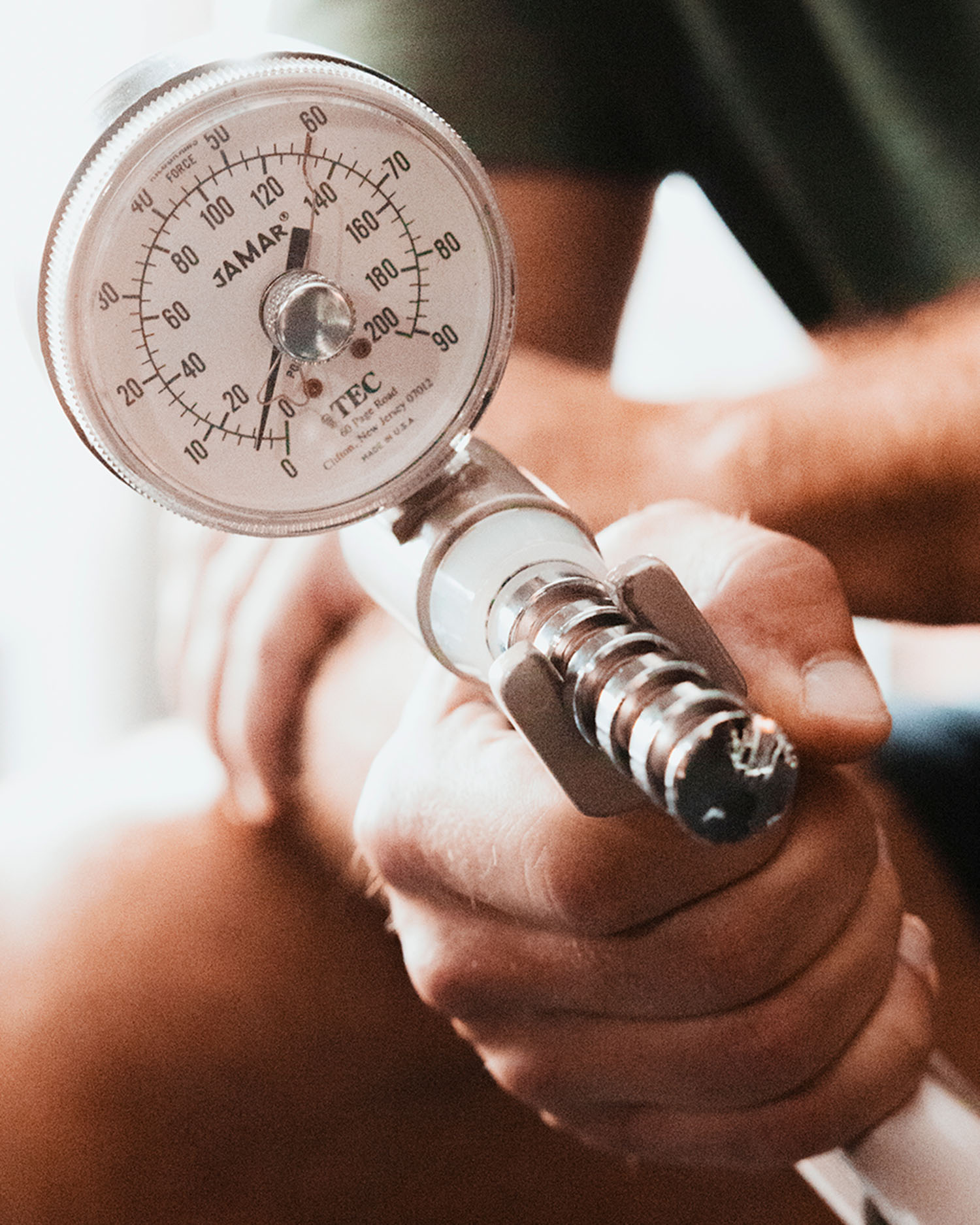 a man squeezing a grip strength tester