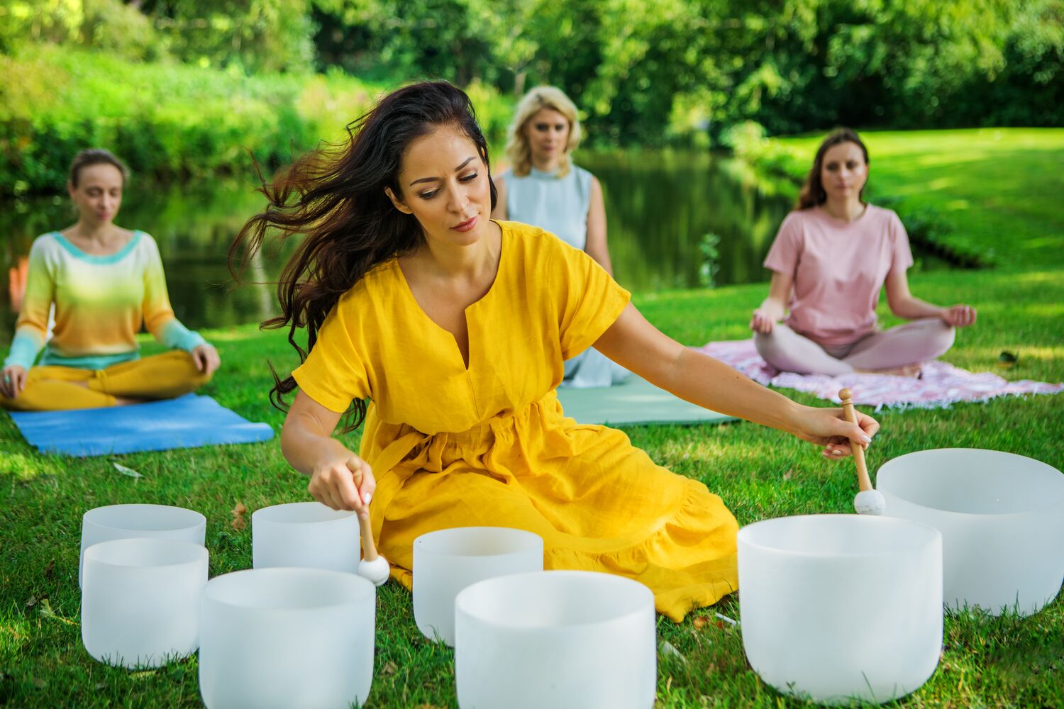 A women leading an outdoor sound bath group experience