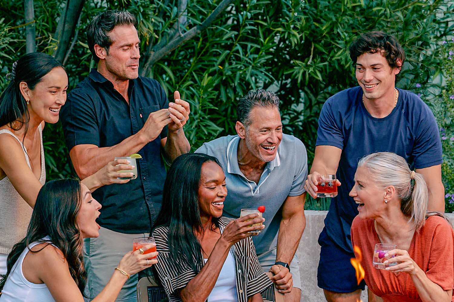 A group enjoying drinks by a fire pit